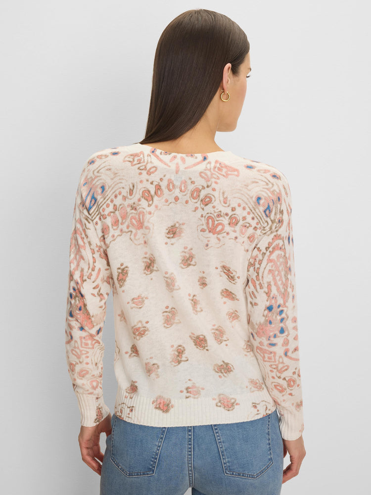 Off-white long-sleeved sweater with peach, blue, and tan paisley pattern, ribbed trim.