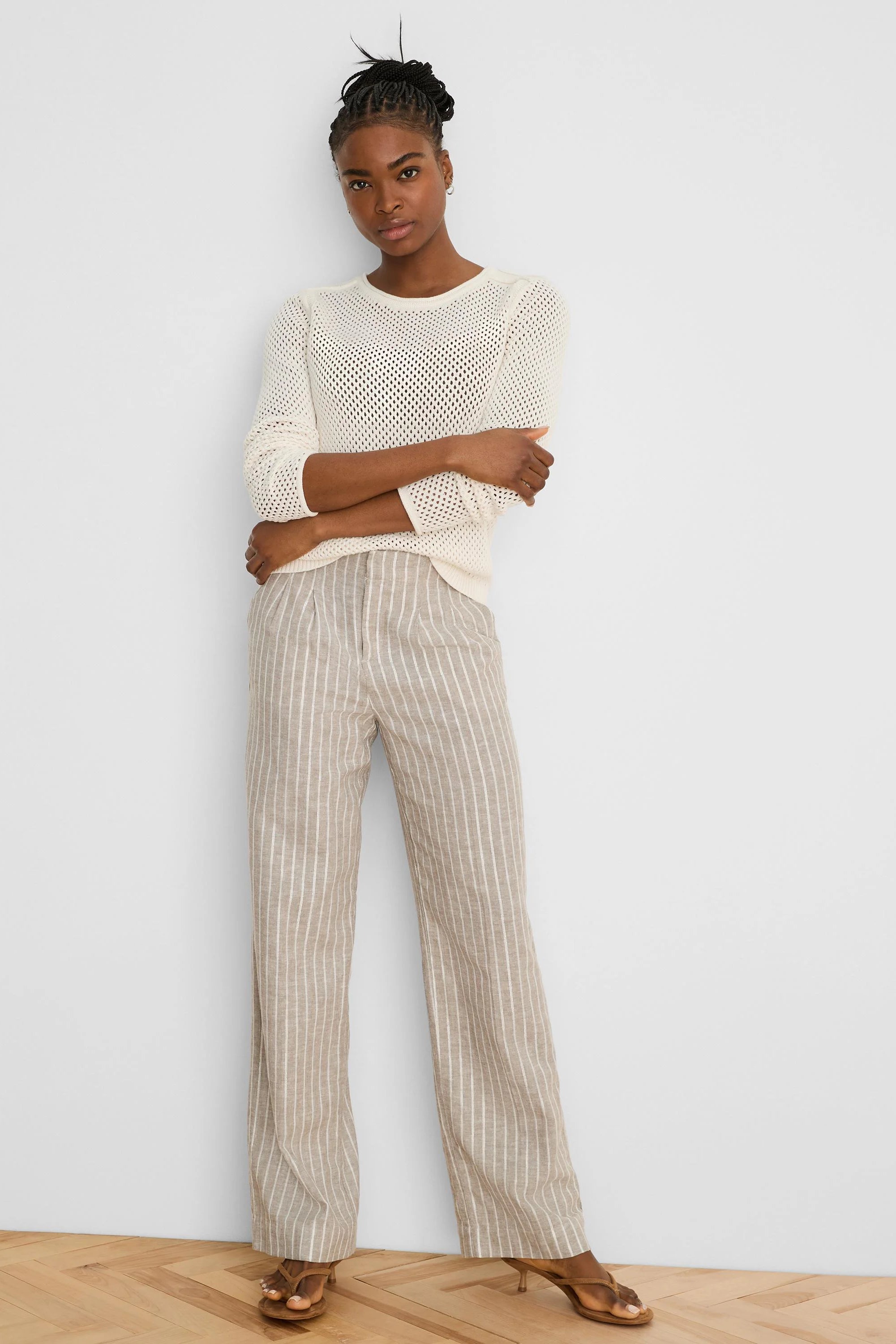 Cream open-knit sweater with a crew neck and long sleeves.