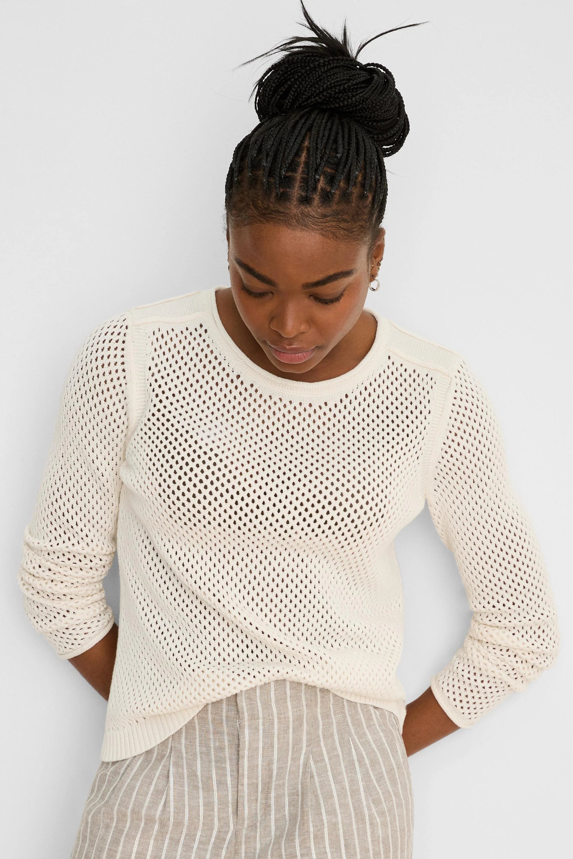 Off-white open knit mesh sweater with a crew neck, long sleeves, and ribbed trim.