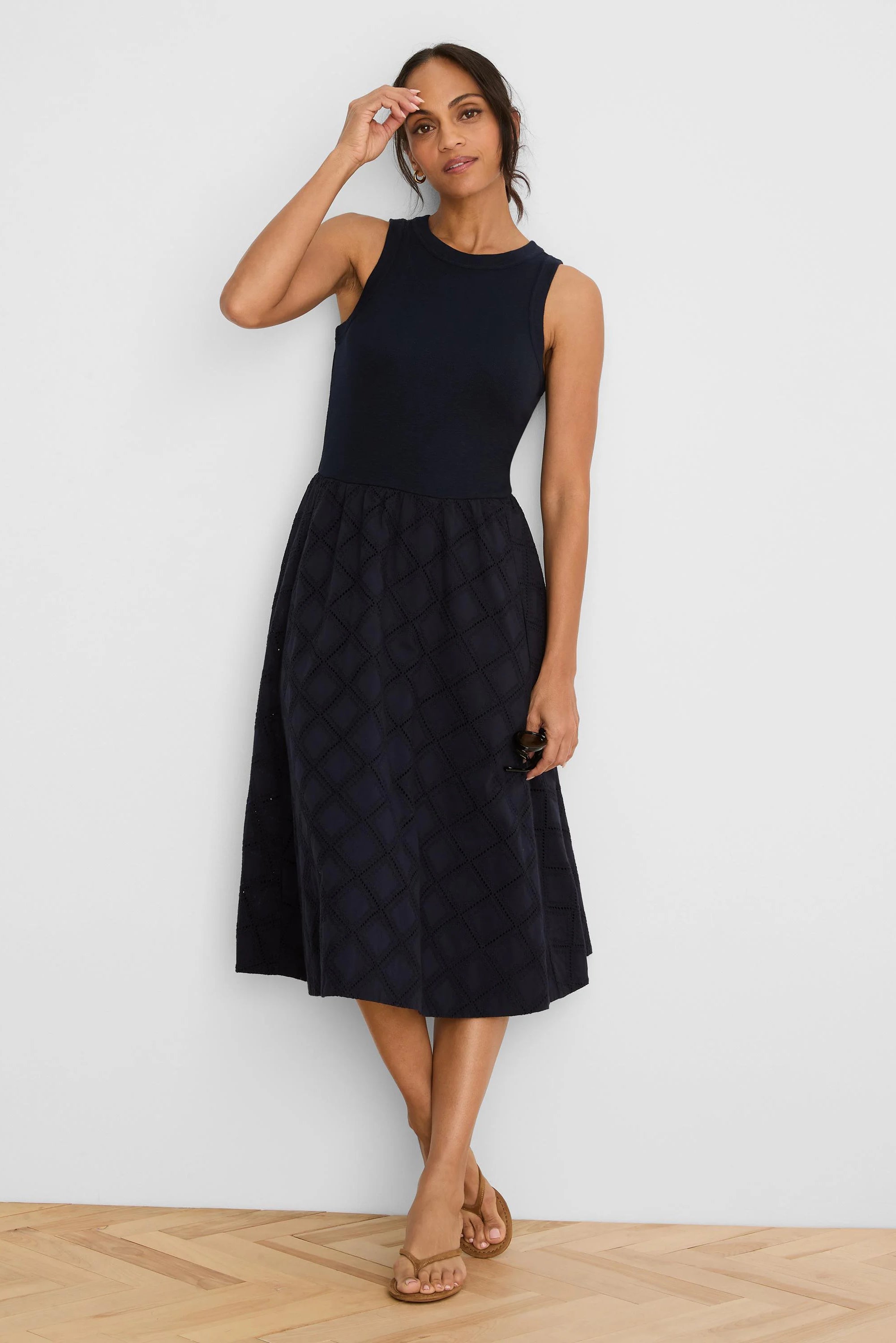 Navy sleeveless midi dress with a ribbed bodice and a skirt featuring diamond eyelet patterns.