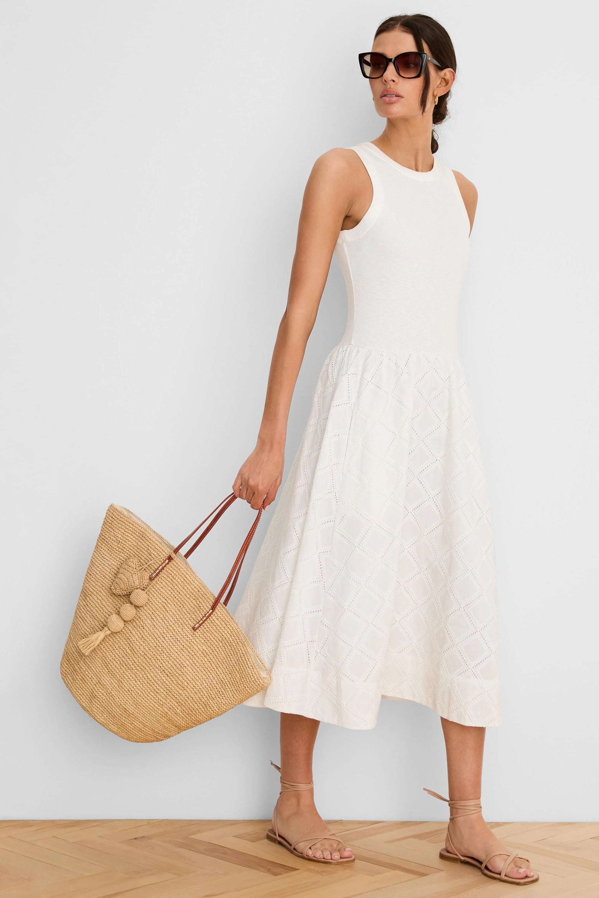 Cream sleeveless midi dress with a fitted bodice and flared skirt featuring a diamond eyelet pattern.