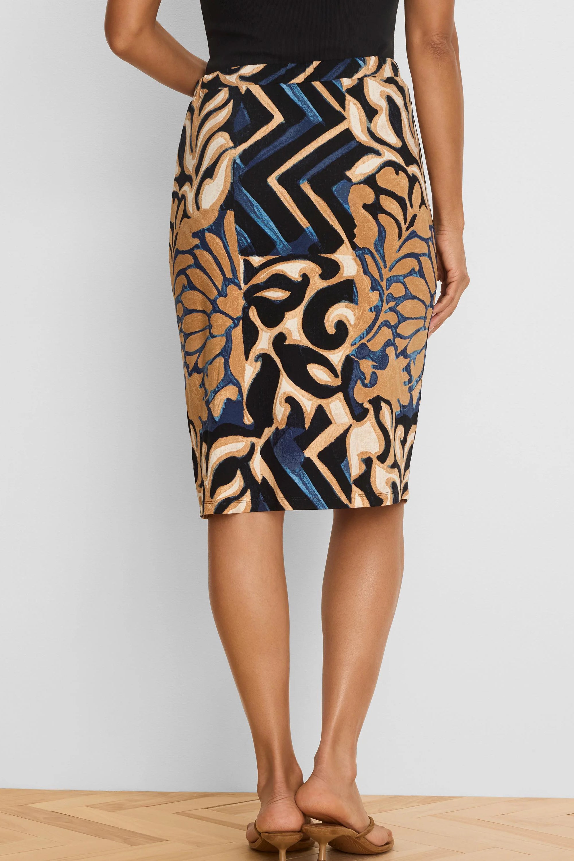 Black knit pencil skirt with tan, cream, and blue abstract pattern featuring fluid shapes and zigzags.