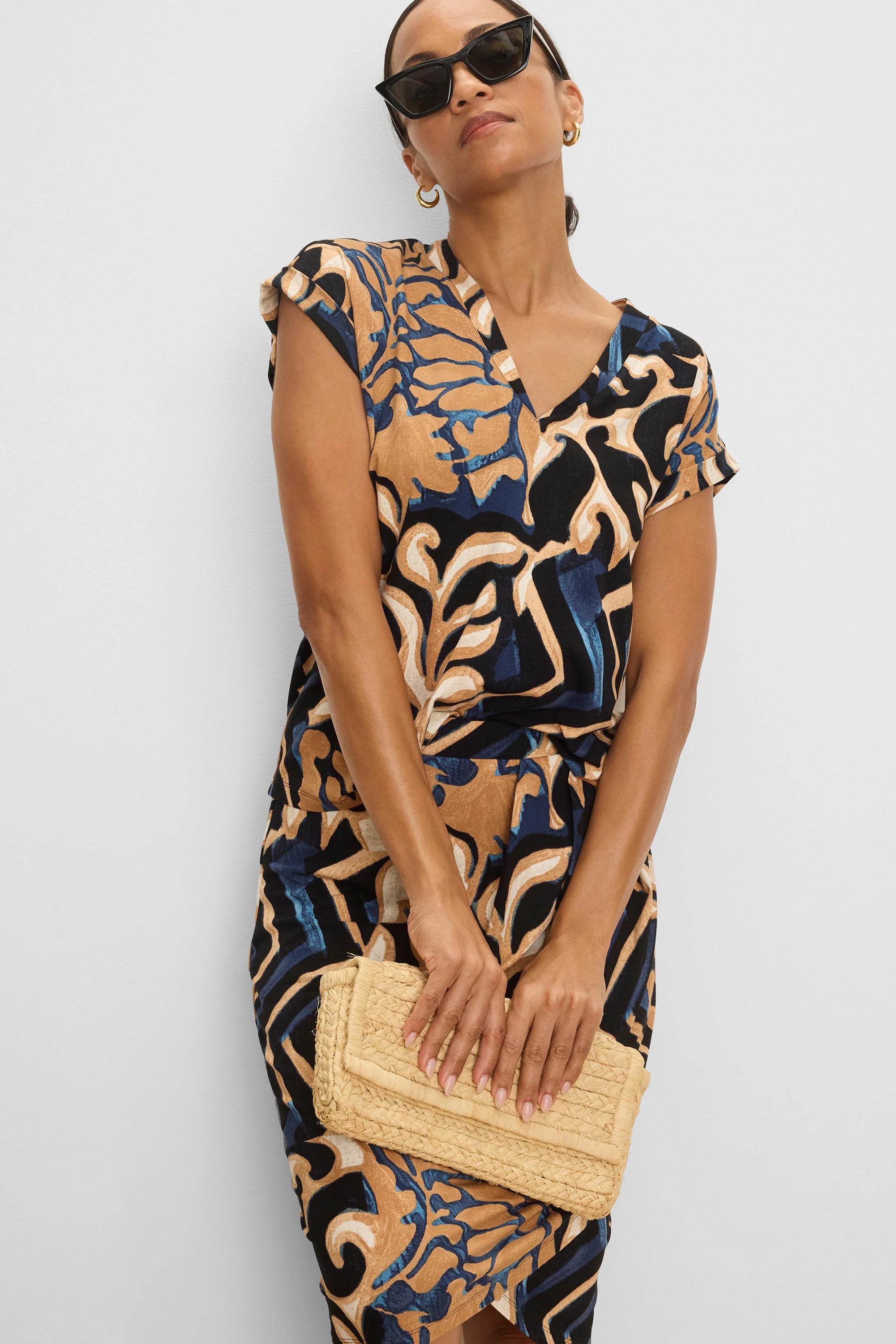 Fitted knit skirt with abstract tan, dark blue, and black 'Deco Blooms' pattern.