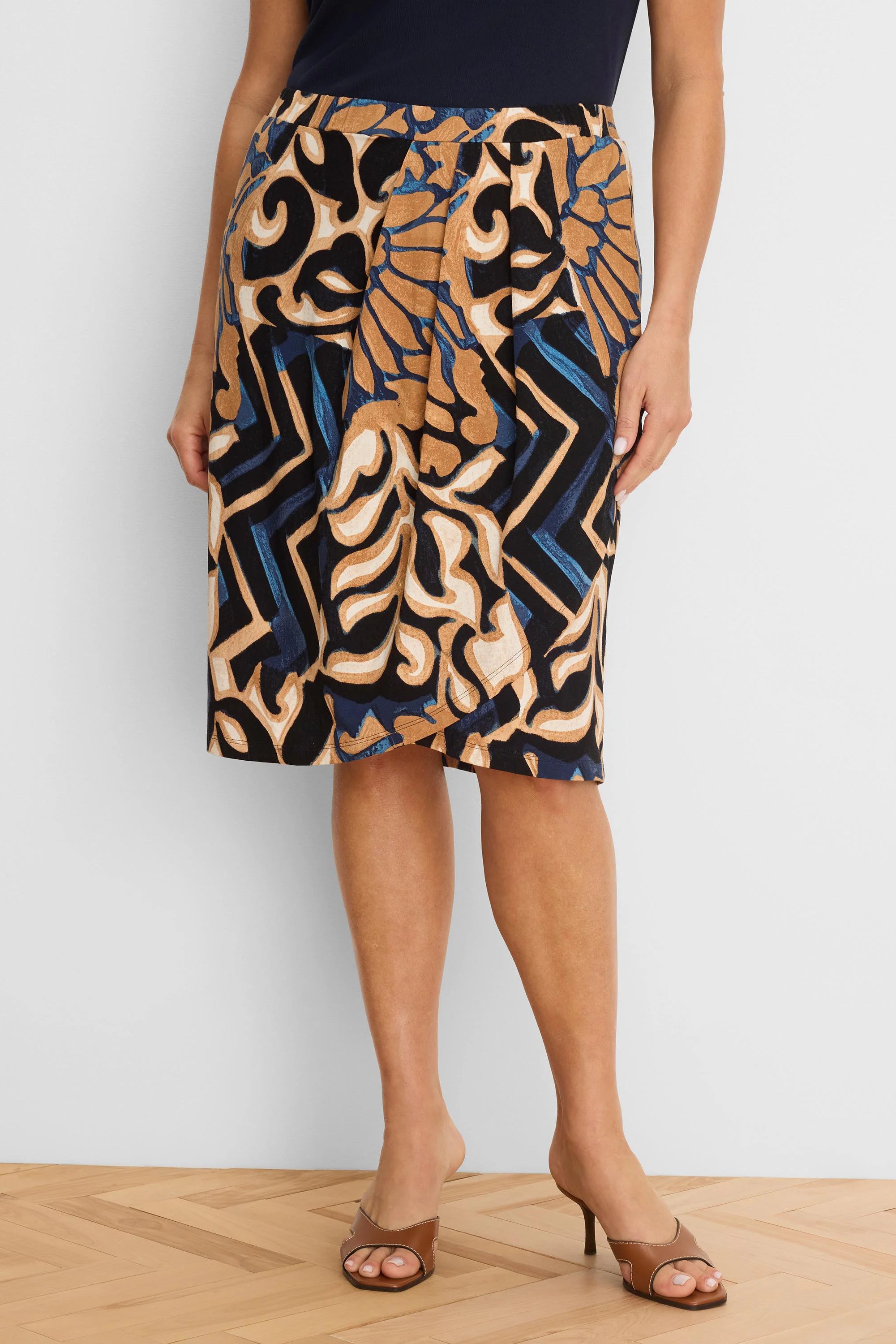 Knee-length knit skirt with an abstract deco pattern in black, tan, blue, and cream colors.