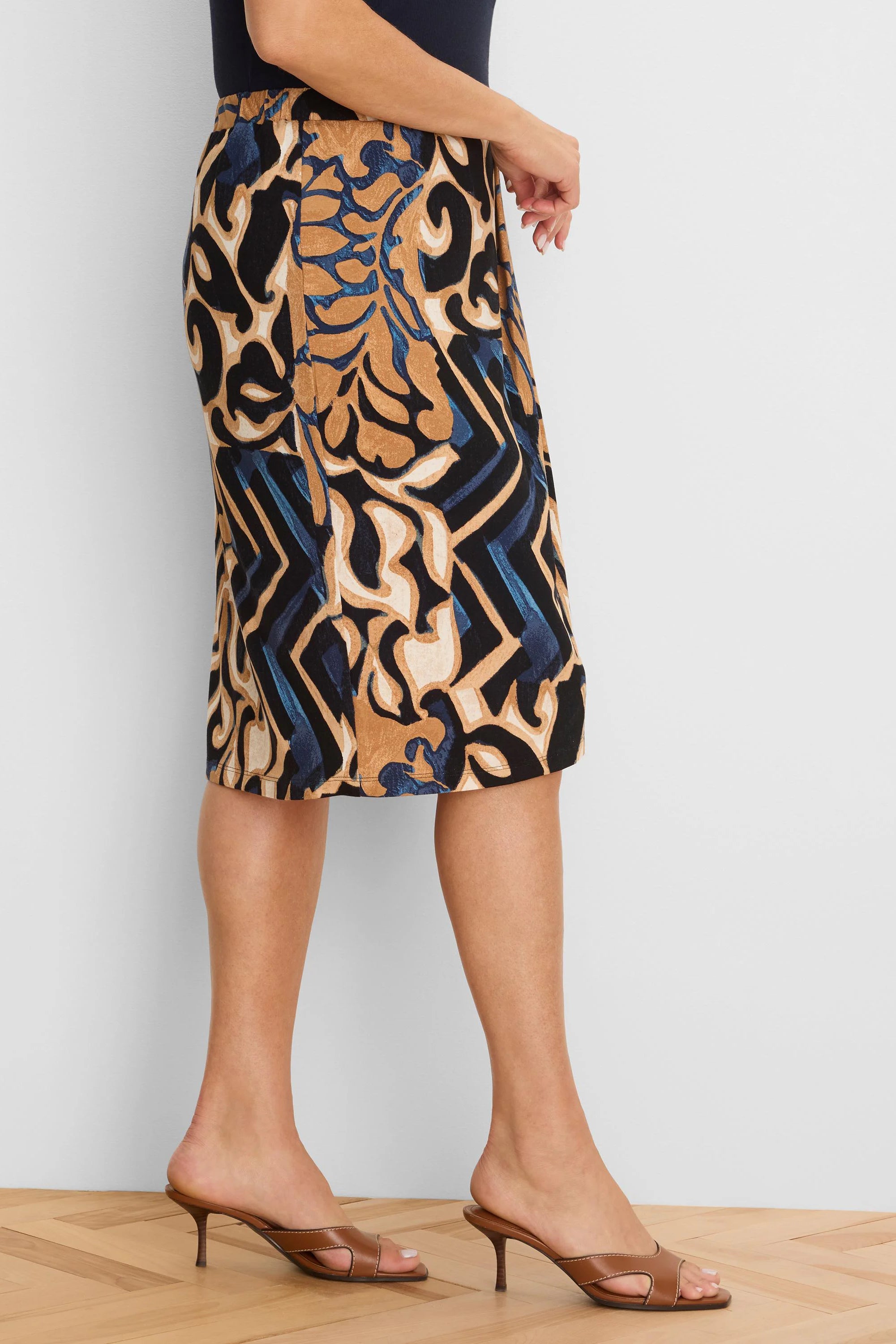 Black knit skirt with knee-length hem, detailed with swirling abstract tan, cream, and blue patterns.