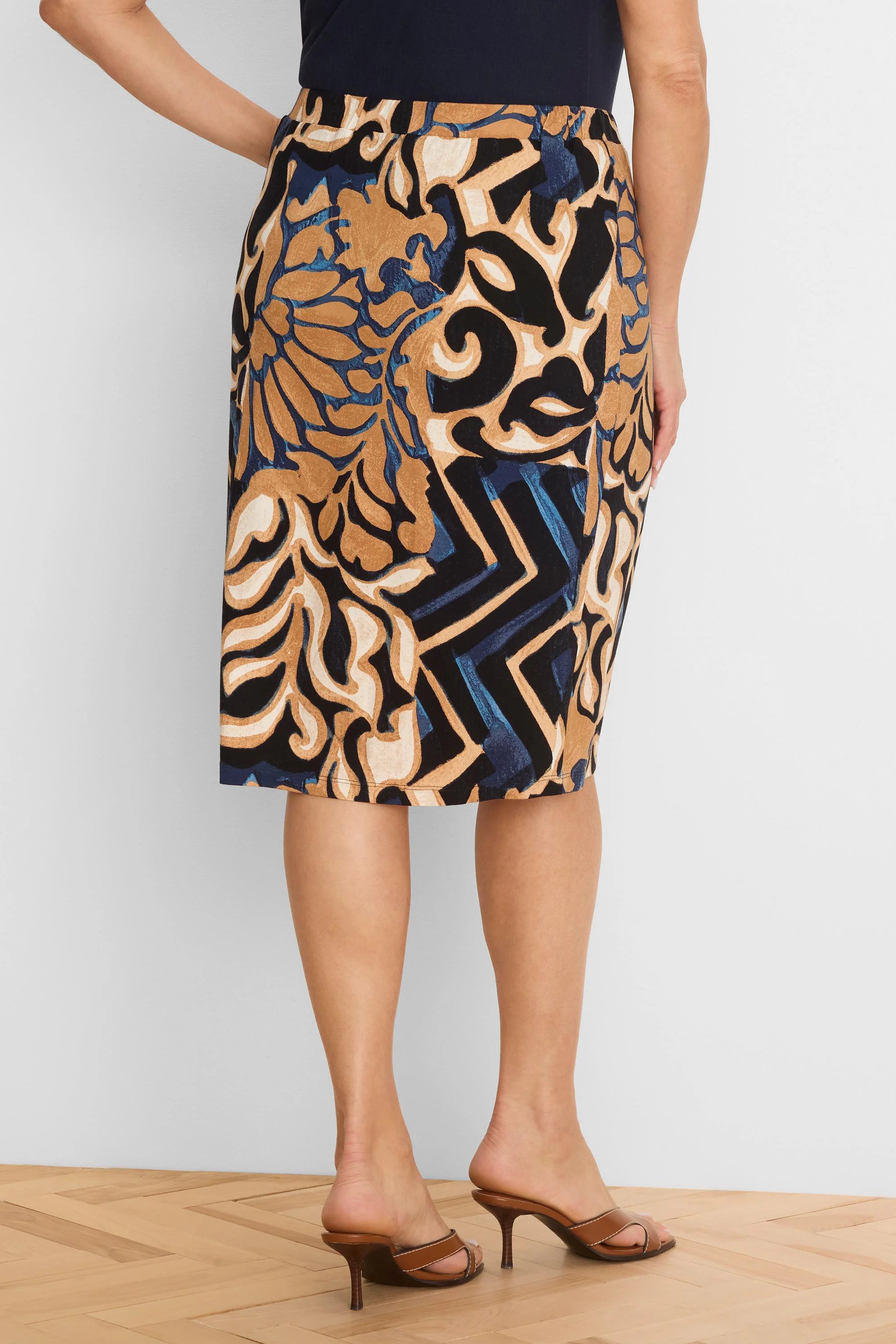 Knit knee-length skirt with black, tan, cream, blue stylized floral-geometric pattern.