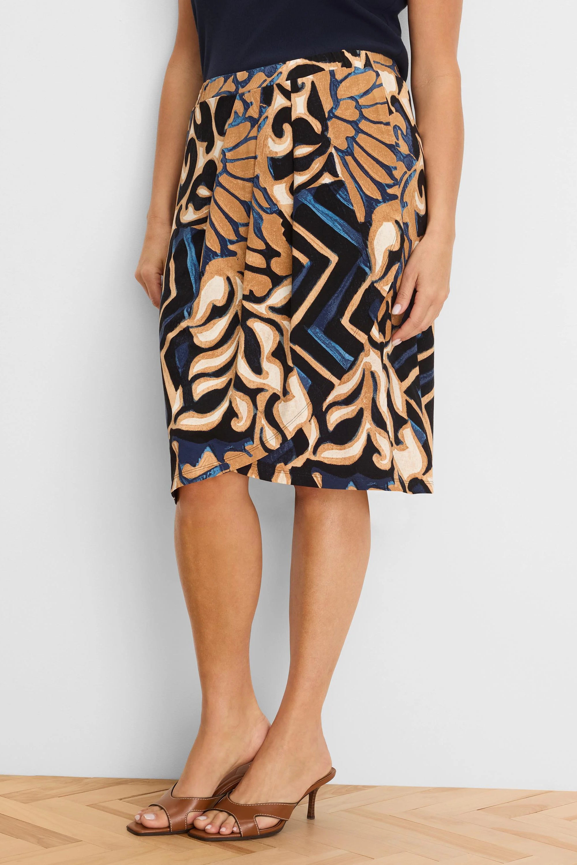 Knit midi skirt with an abstract pattern in black, tan, blue, and cream.