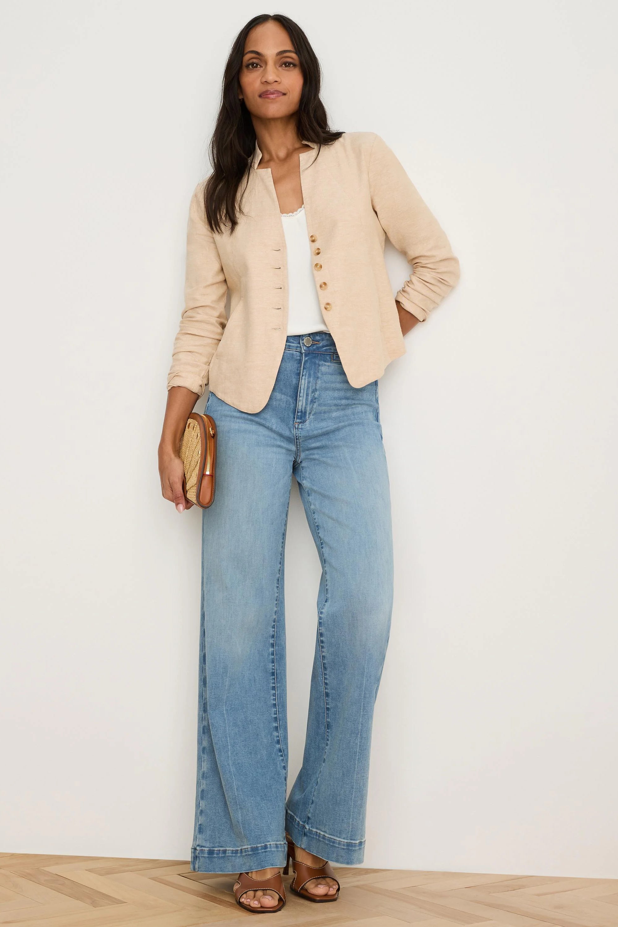 Light beige linen jacket, collarless with split neckline & single row of small brown buttons. Sleeves are rolled.