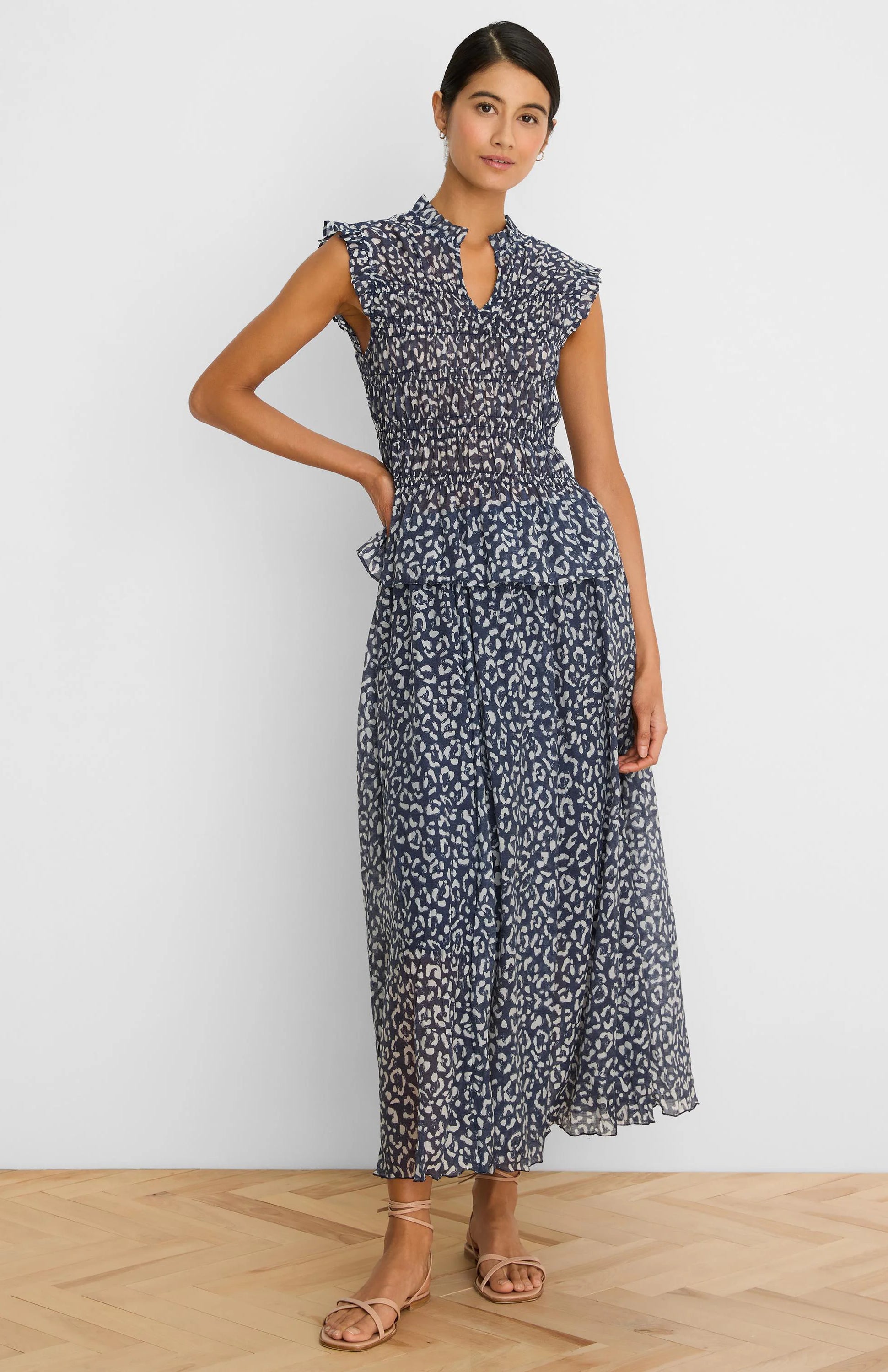 Navy smocked top with white leopard sketch print, mock neck, V-notch, and ruffled cap sleeves.