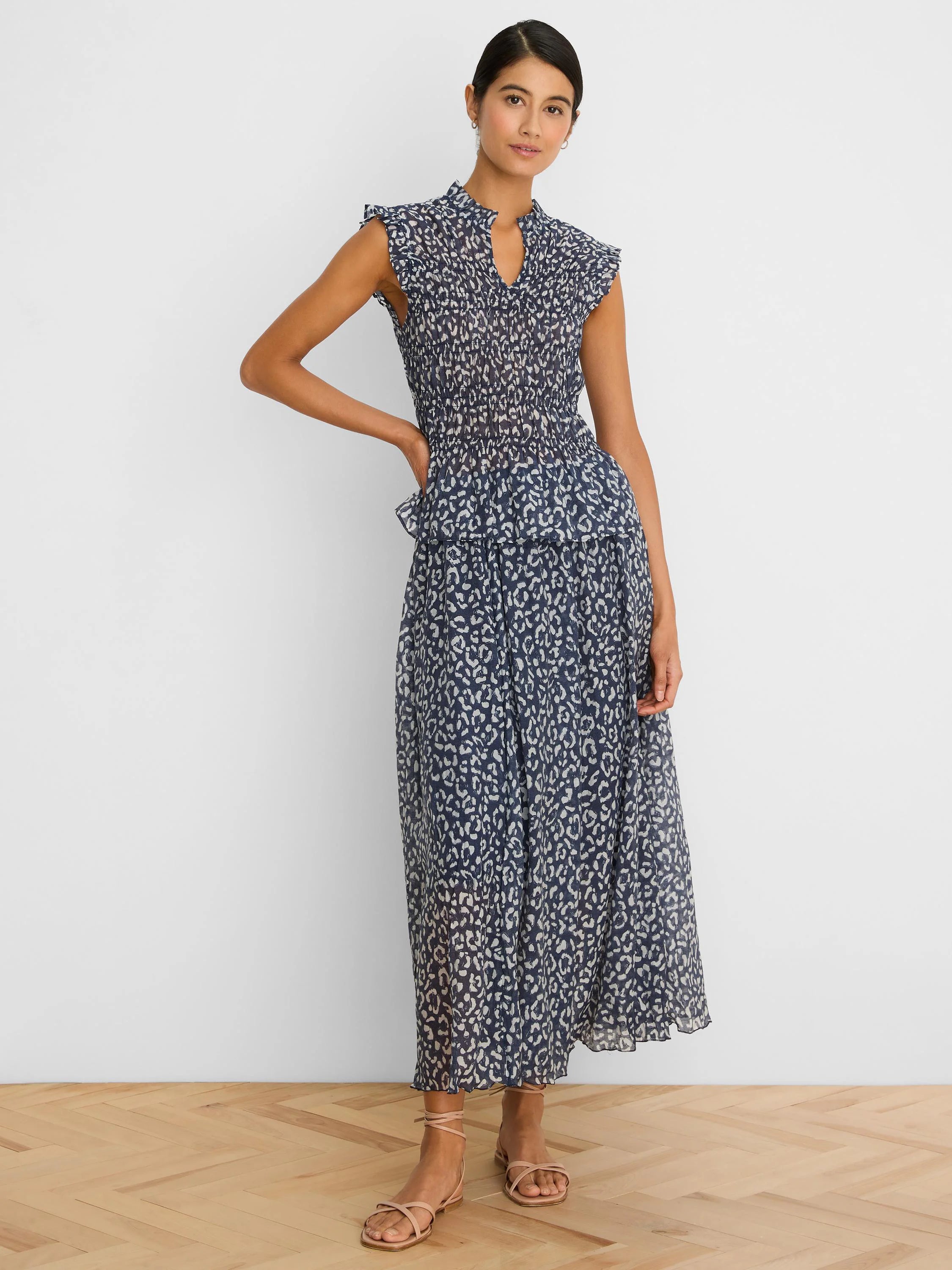 Navy smocked top with white leopard sketch print, mock neck, V-notch, and ruffled cap sleeves.