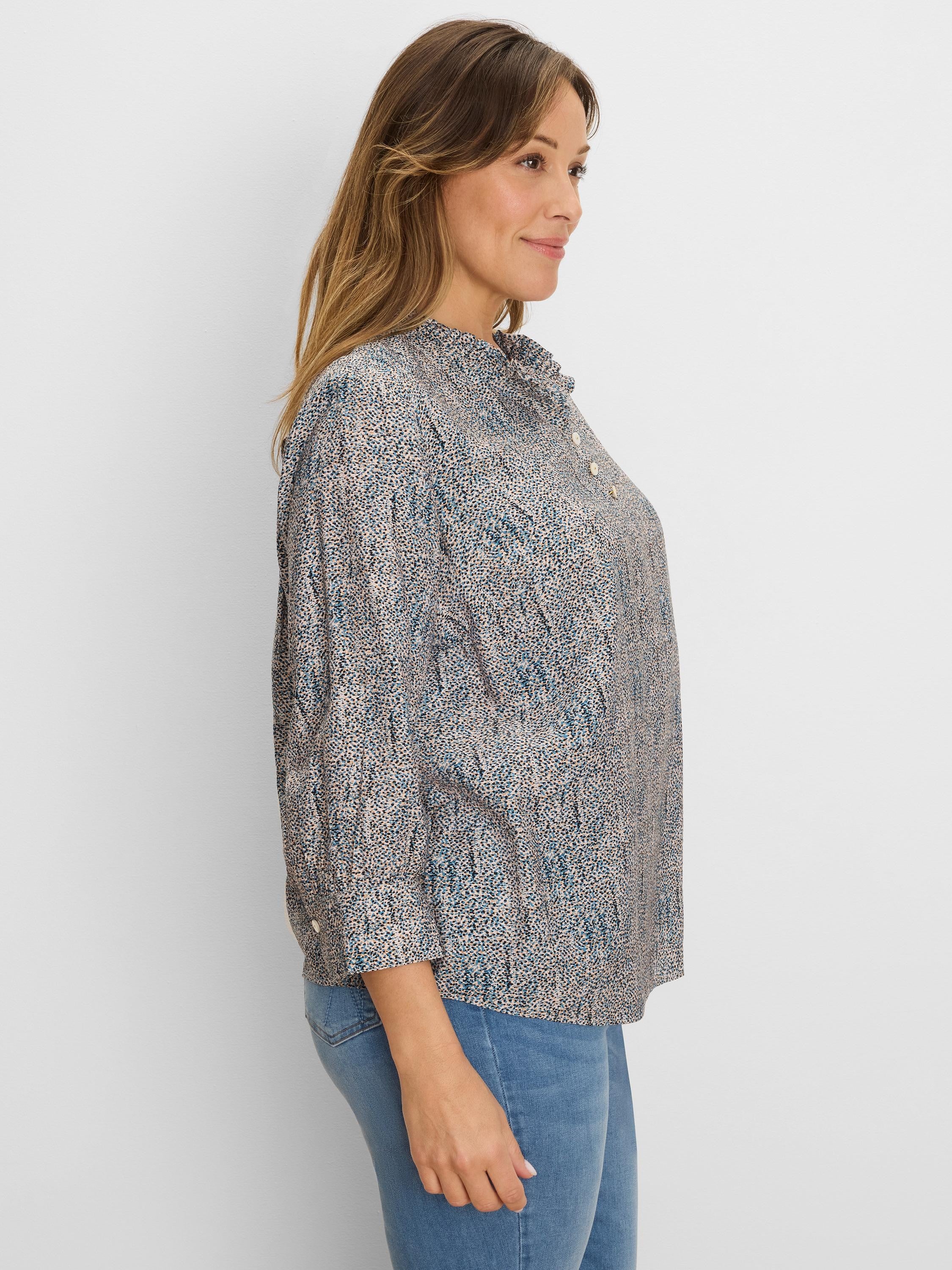 Loose top with blue, brown, and black speckled print, ruffle neck, and button placket.