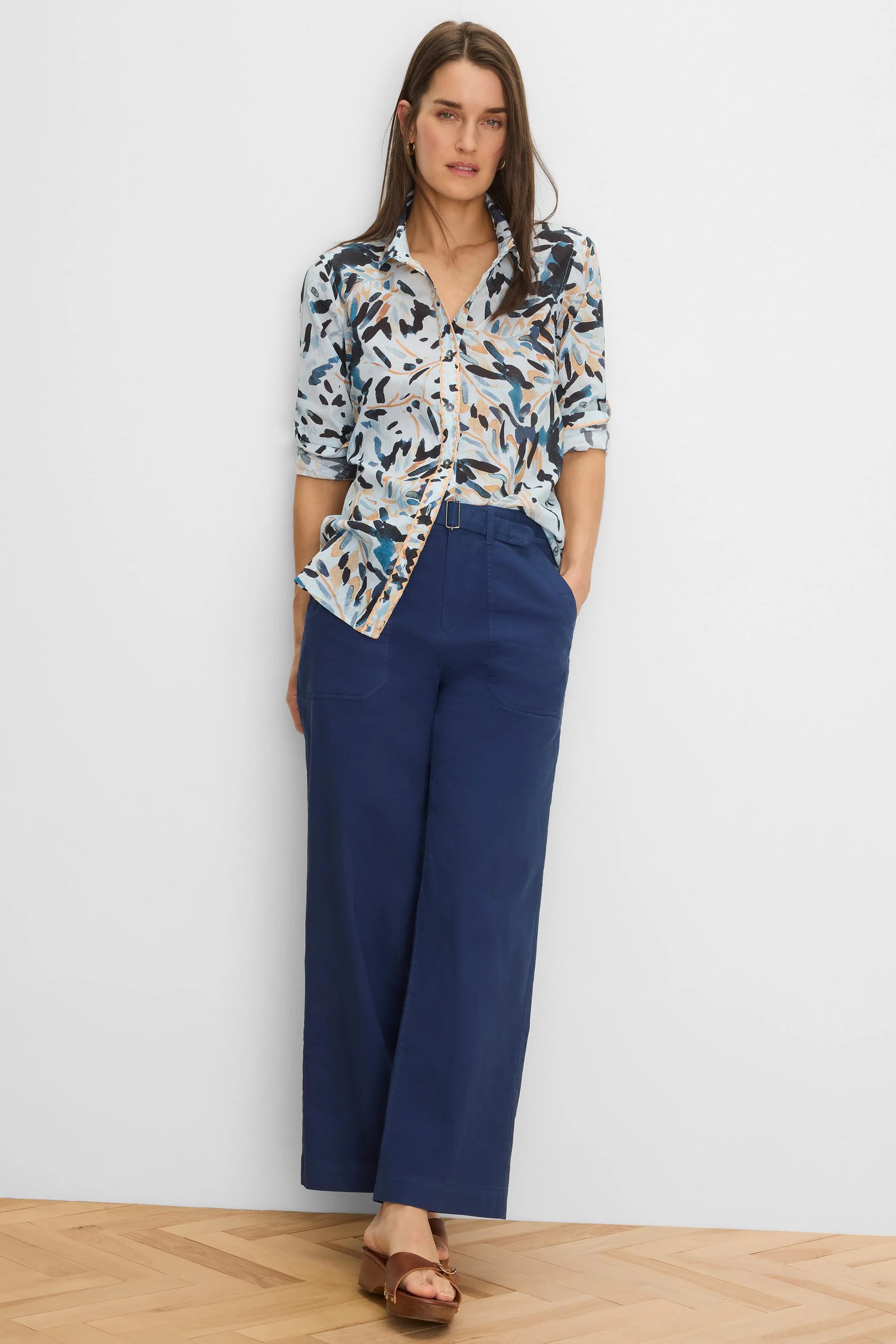 Crinkle shirt: light background with abstract dark blue, tan, black brushstroke pattern. Button-up, rolled sleeves.