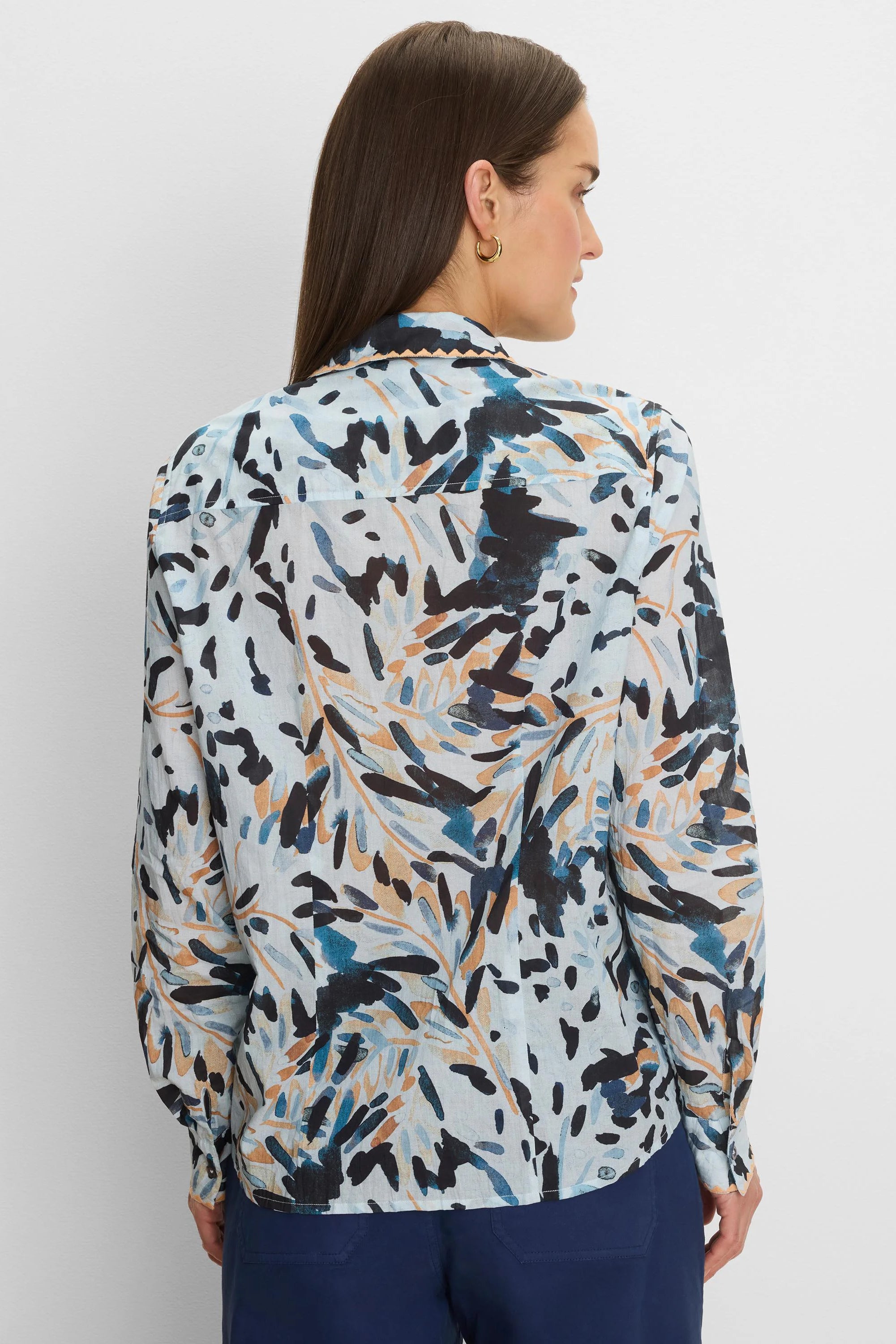 Light blue crinkled shirt with an abstract pattern of dark blue, teal, orange, and black brushstrokes. Scalloped collar.