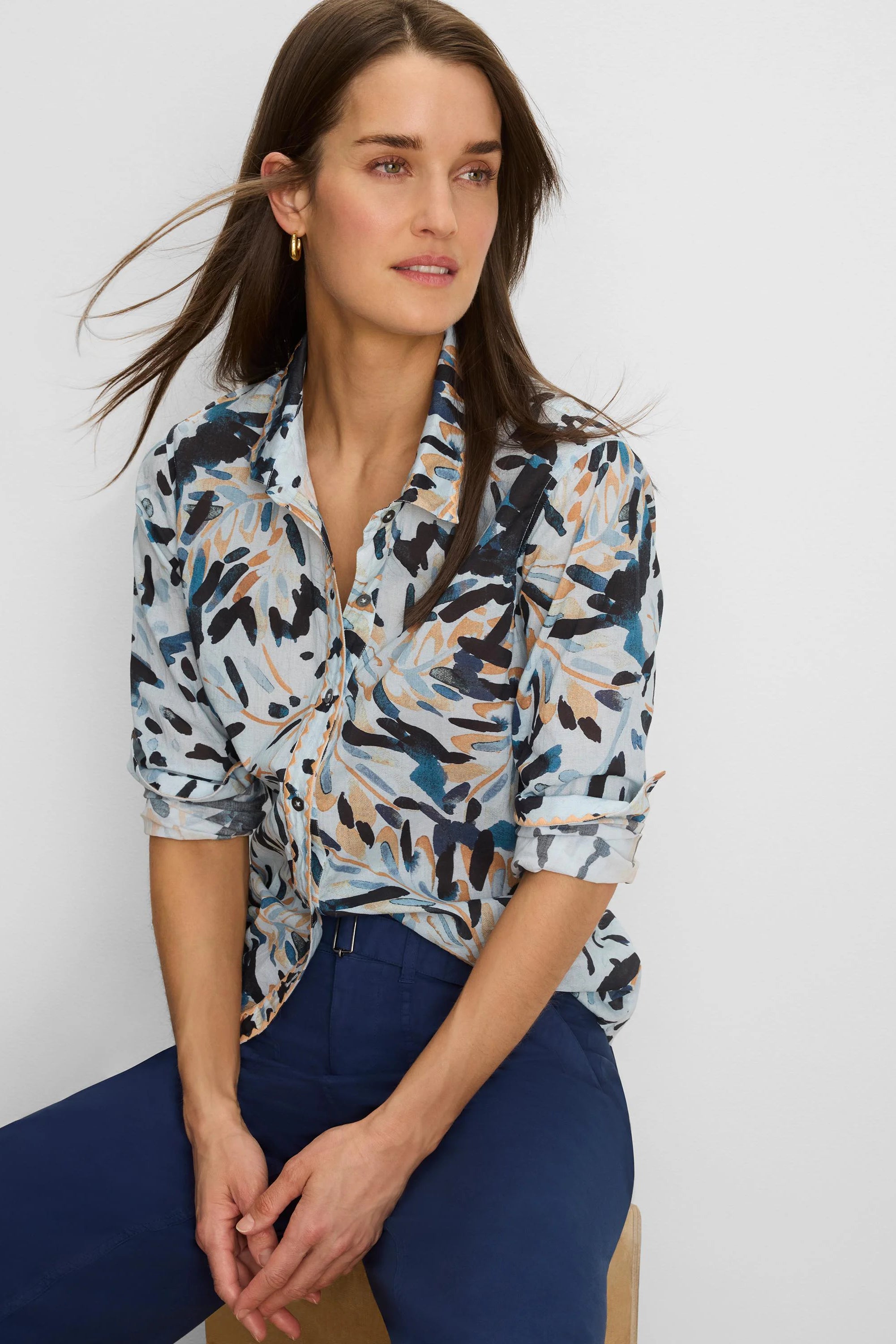 Light blue button-down shirt with abstract navy, teal, and tan brushstroke pattern. Sleeves are rolled up.