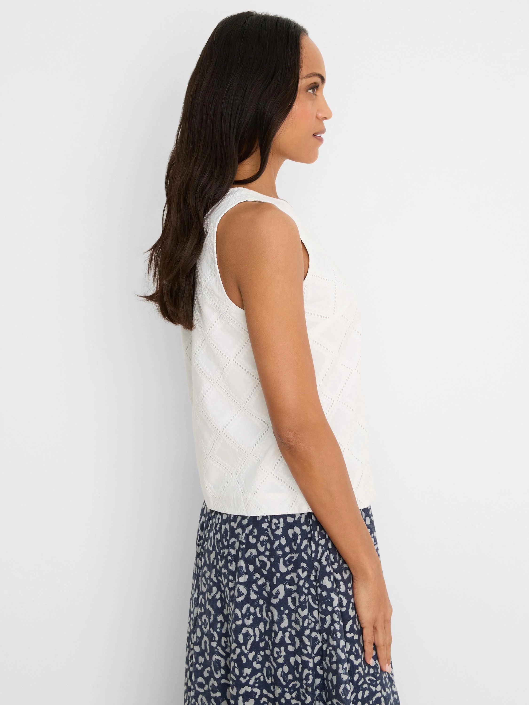 White sleeveless top with a diamond eyelet pattern.