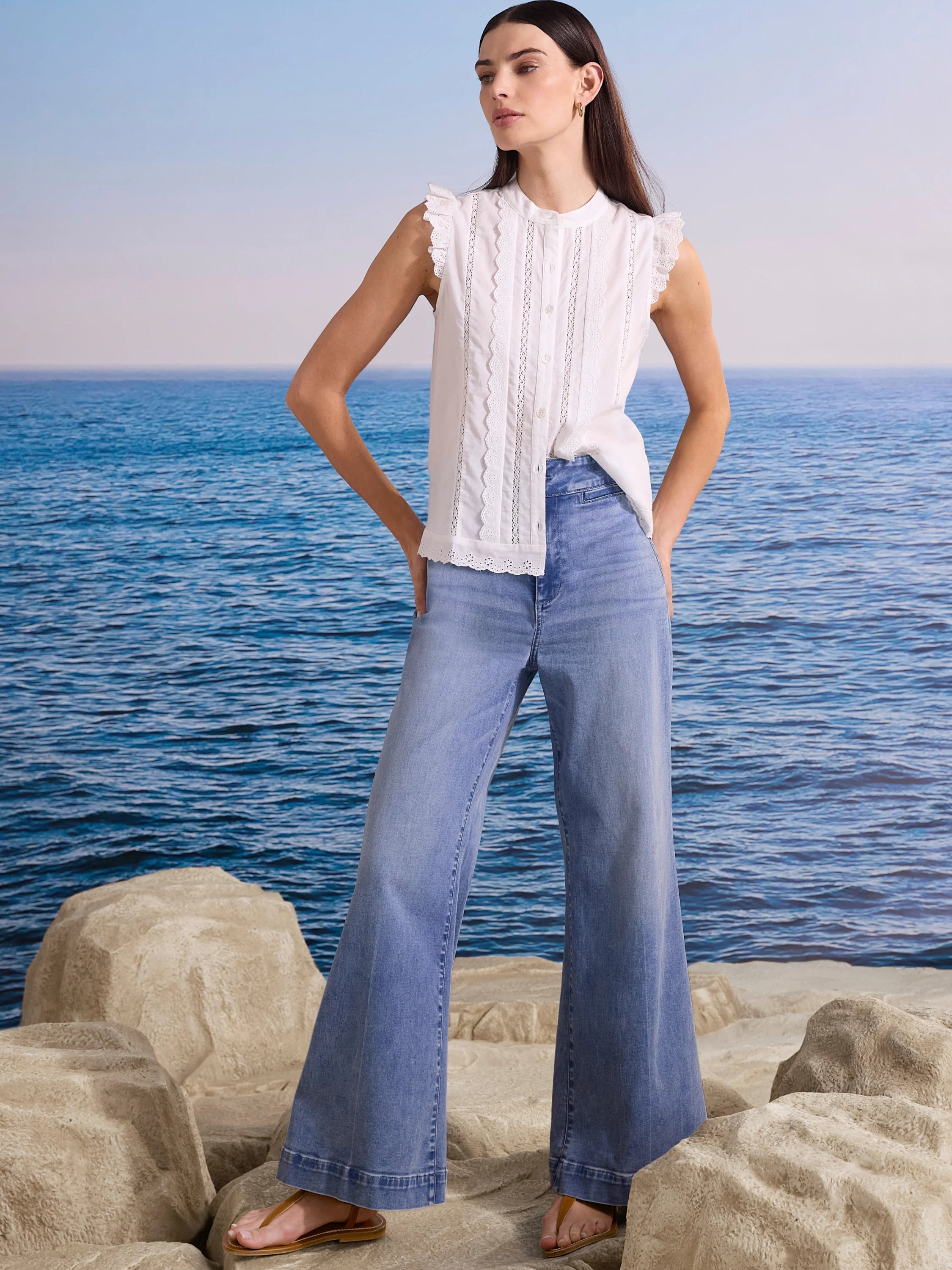 White sleeveless top with frilled shoulders and vertical lace-trimmed pintucks on the front.
