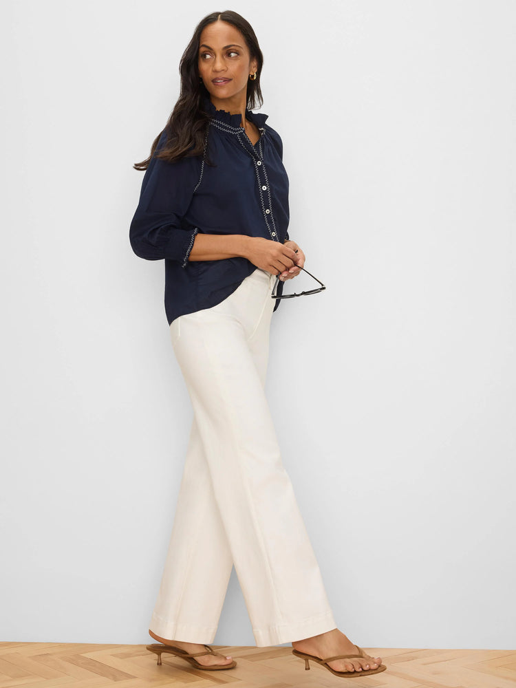 Navy crinkle shirt with white zig-zag stitching on collar, placket, and smocked cuffs.