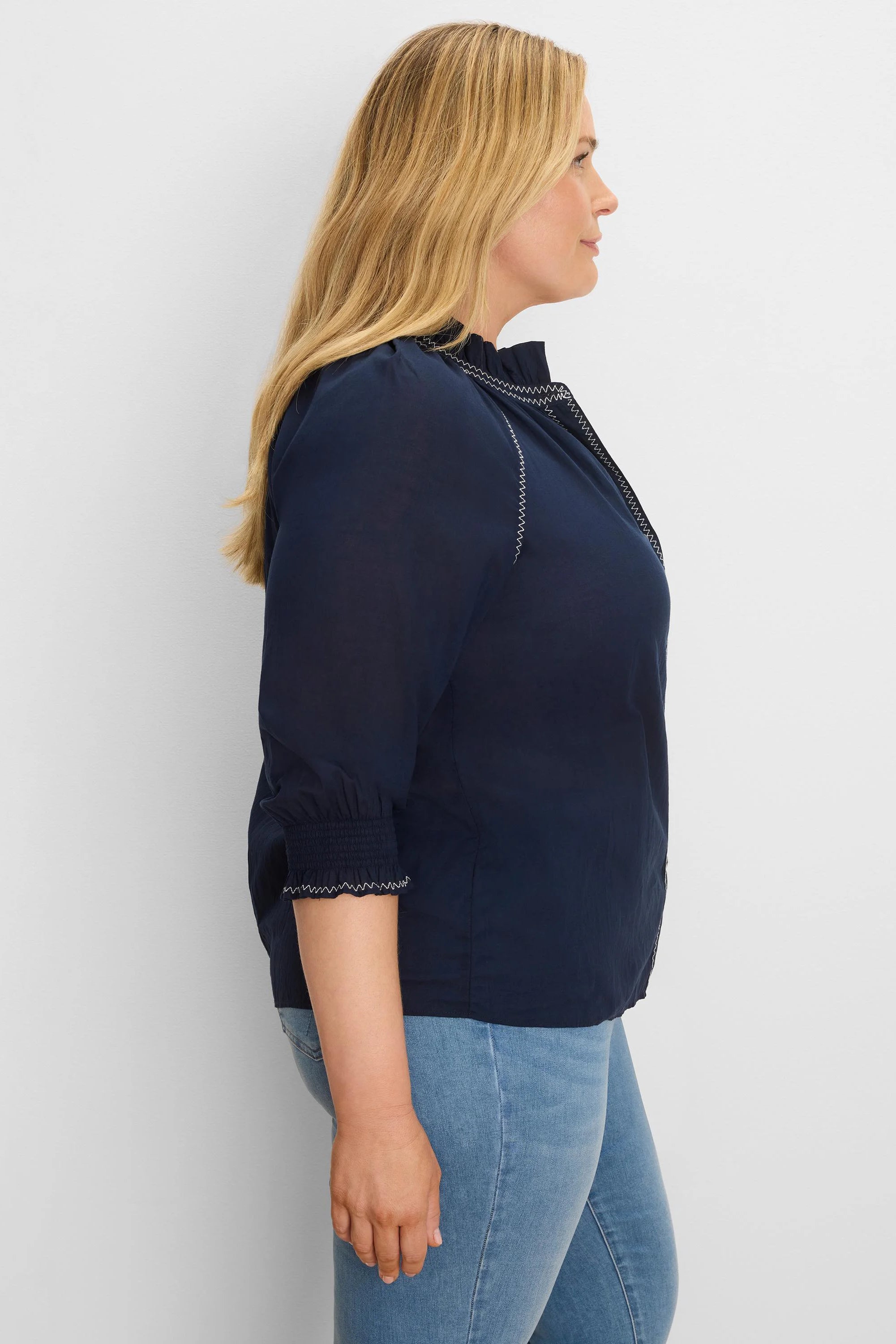 Navy crinkle shirt with white zig-zag stitching on ruffled collar, front, & smocked 3/4 cuffs.
