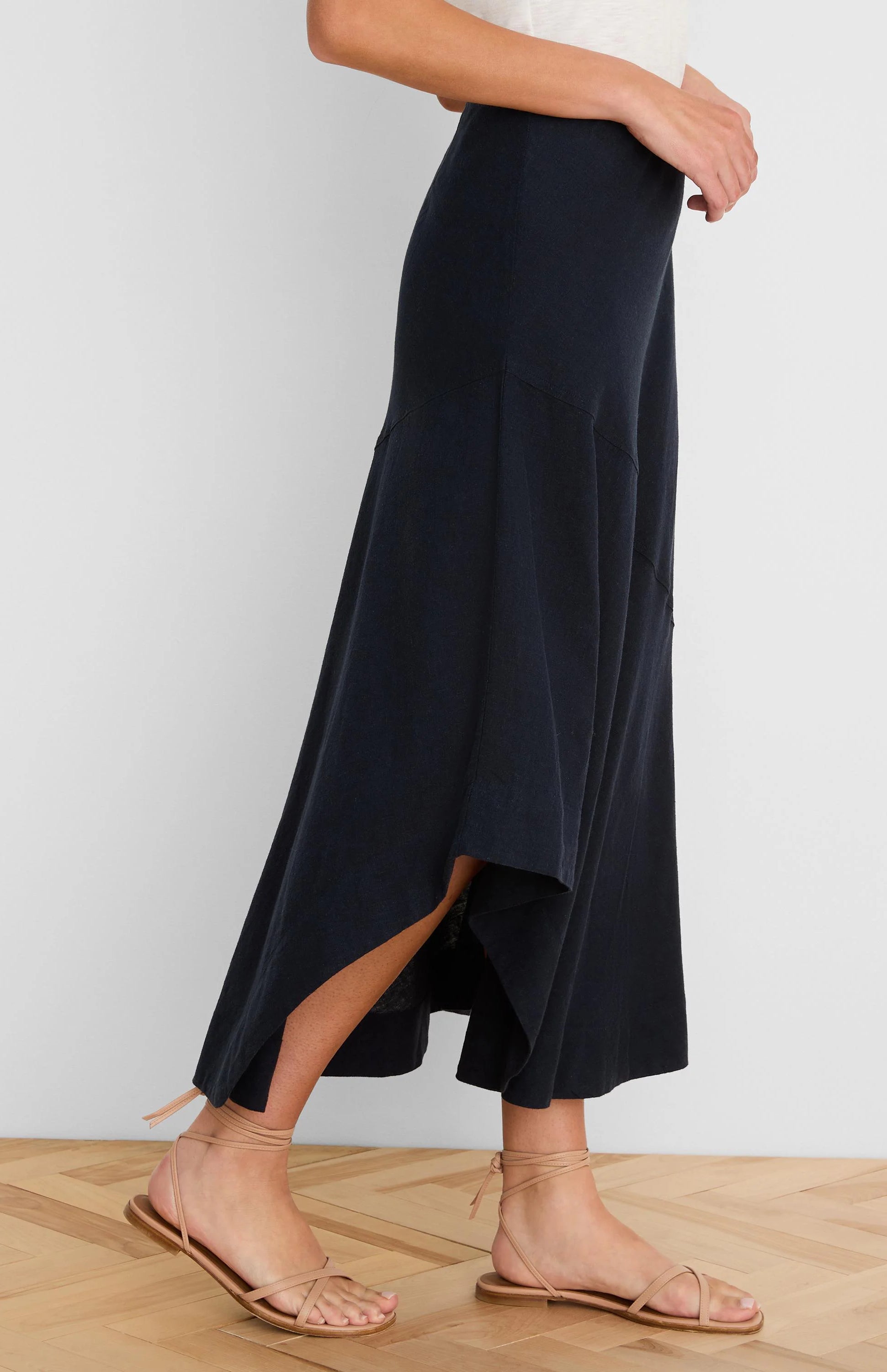 Long dark navy linen skirt with a flowing silhouette, featuring an asymmetrical ruffled high-low hem.