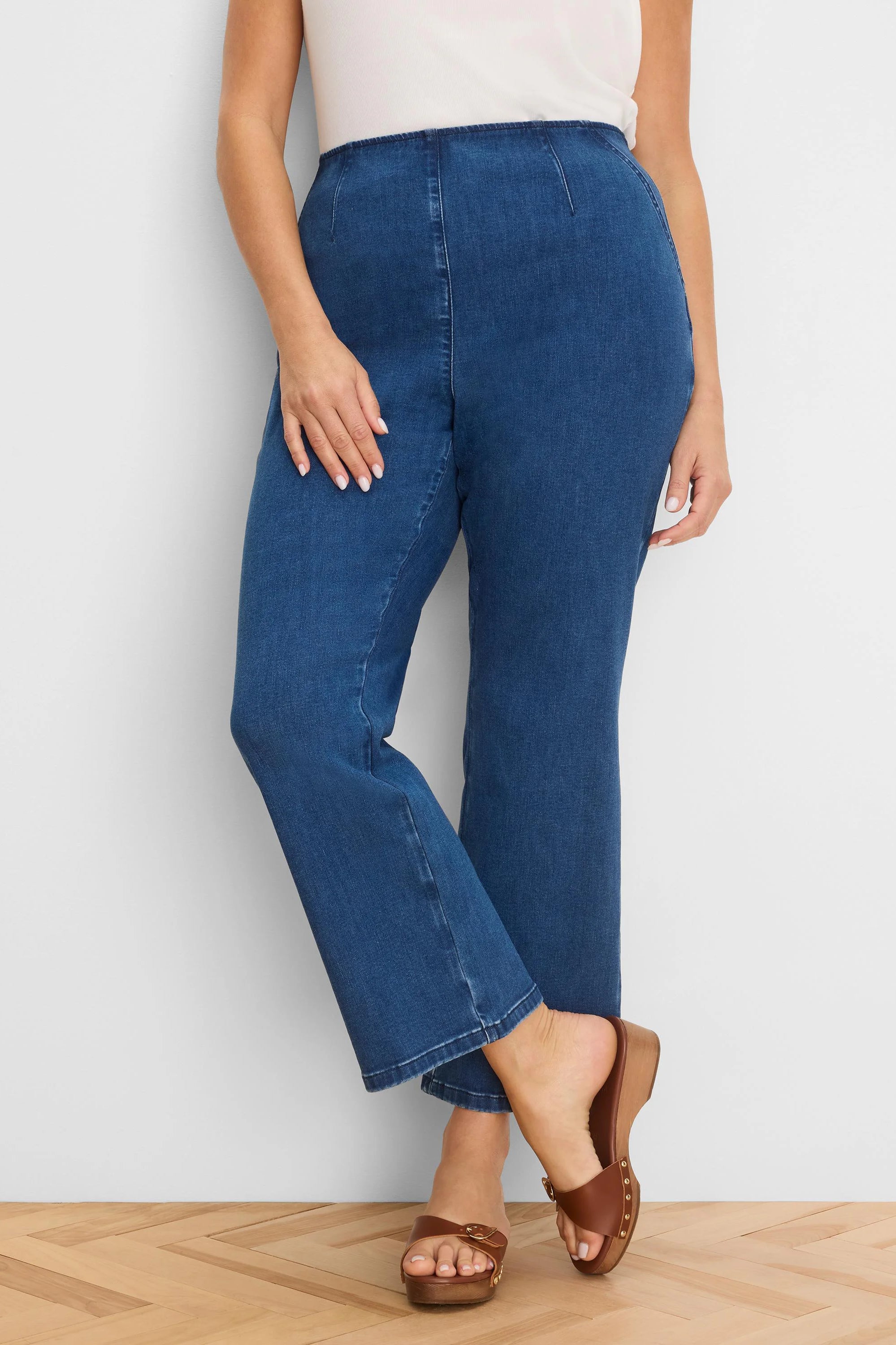 Medium blue high-waist bootcut jeans with visible front and back seams, ending above the ankle.