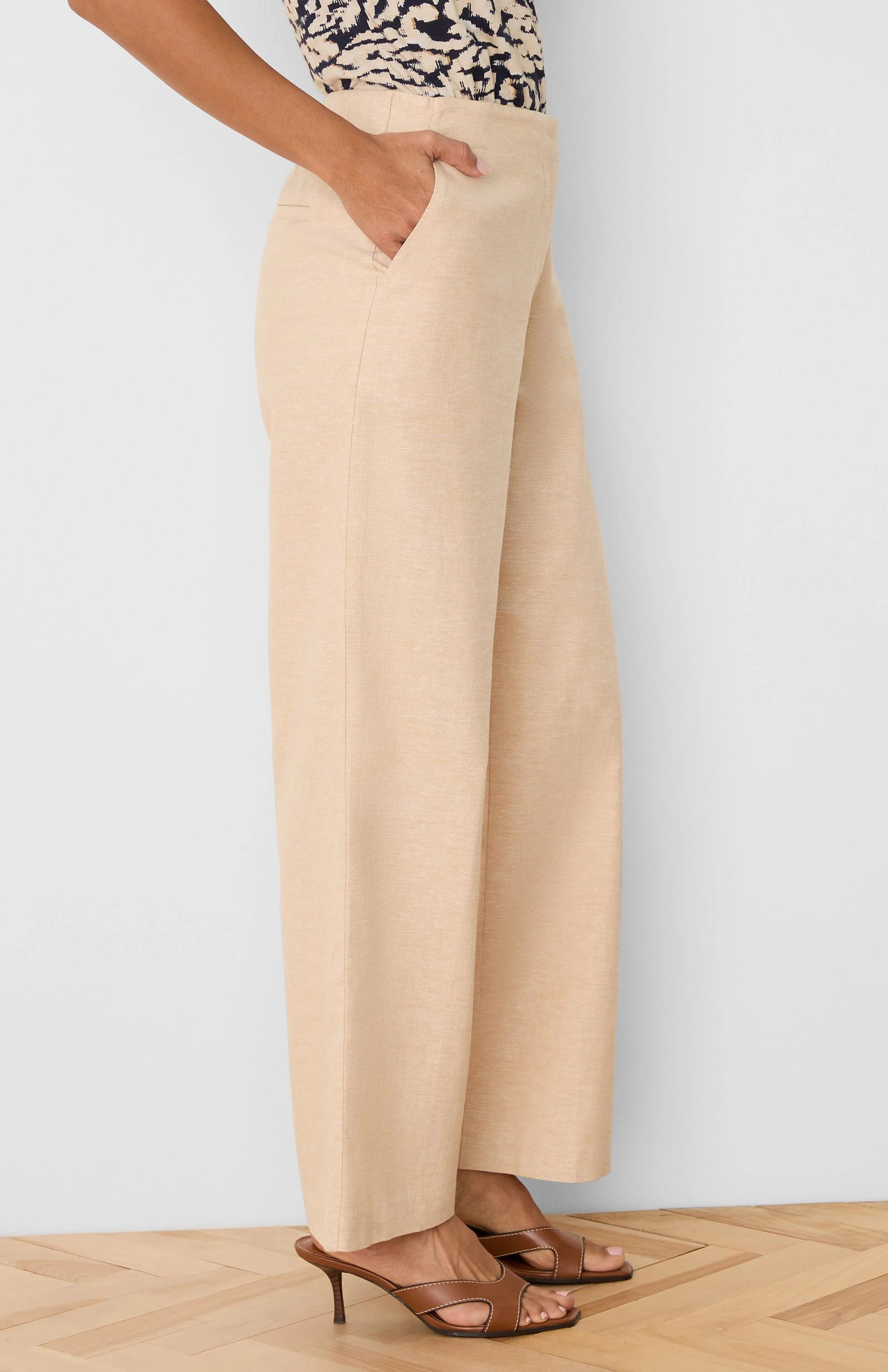 Light beige wide leg linen pants with visible side pockets, shown on a model.