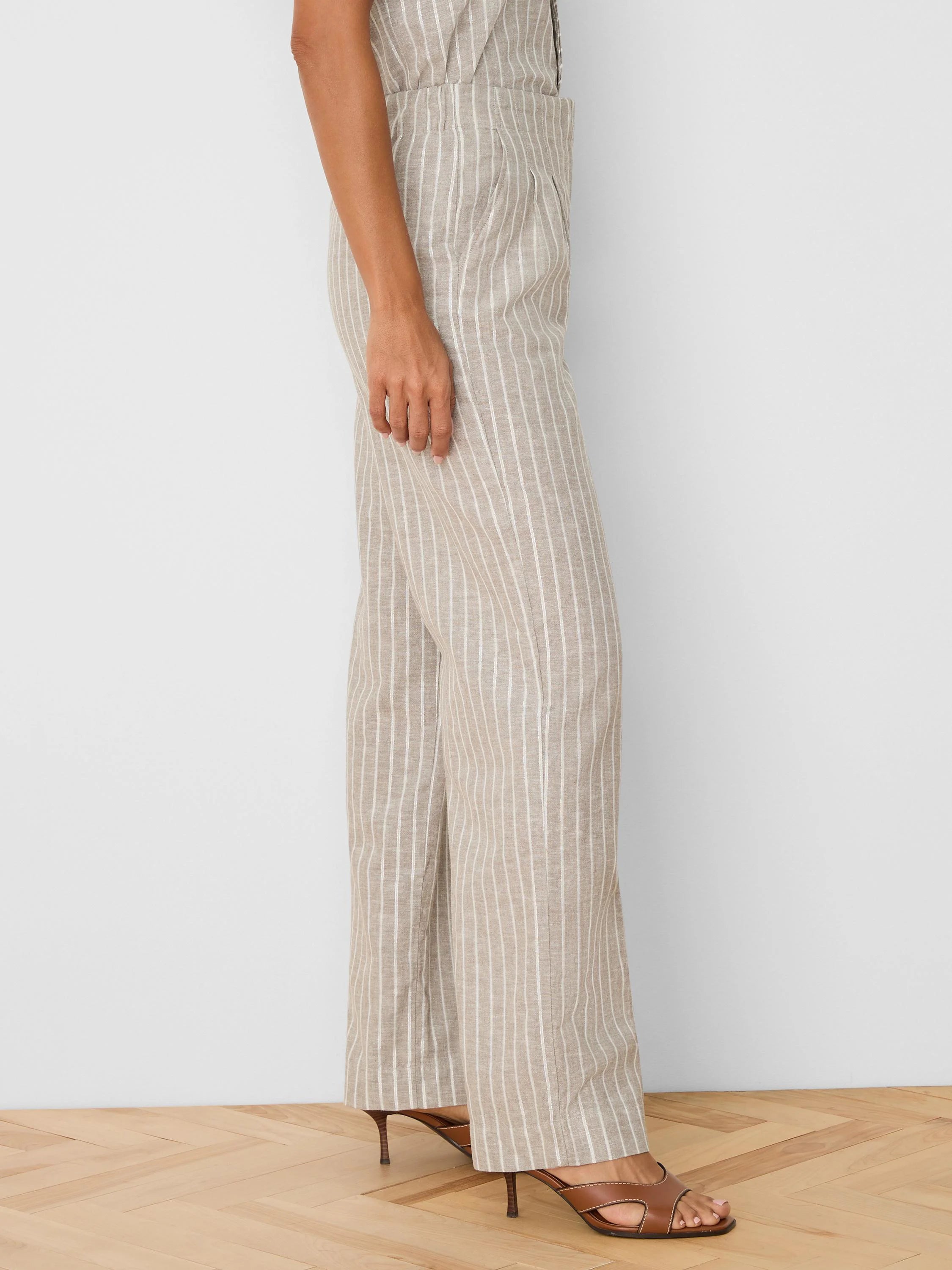 Beige wide-leg linen pants with thin vertical white stripes and visible side pockets.
