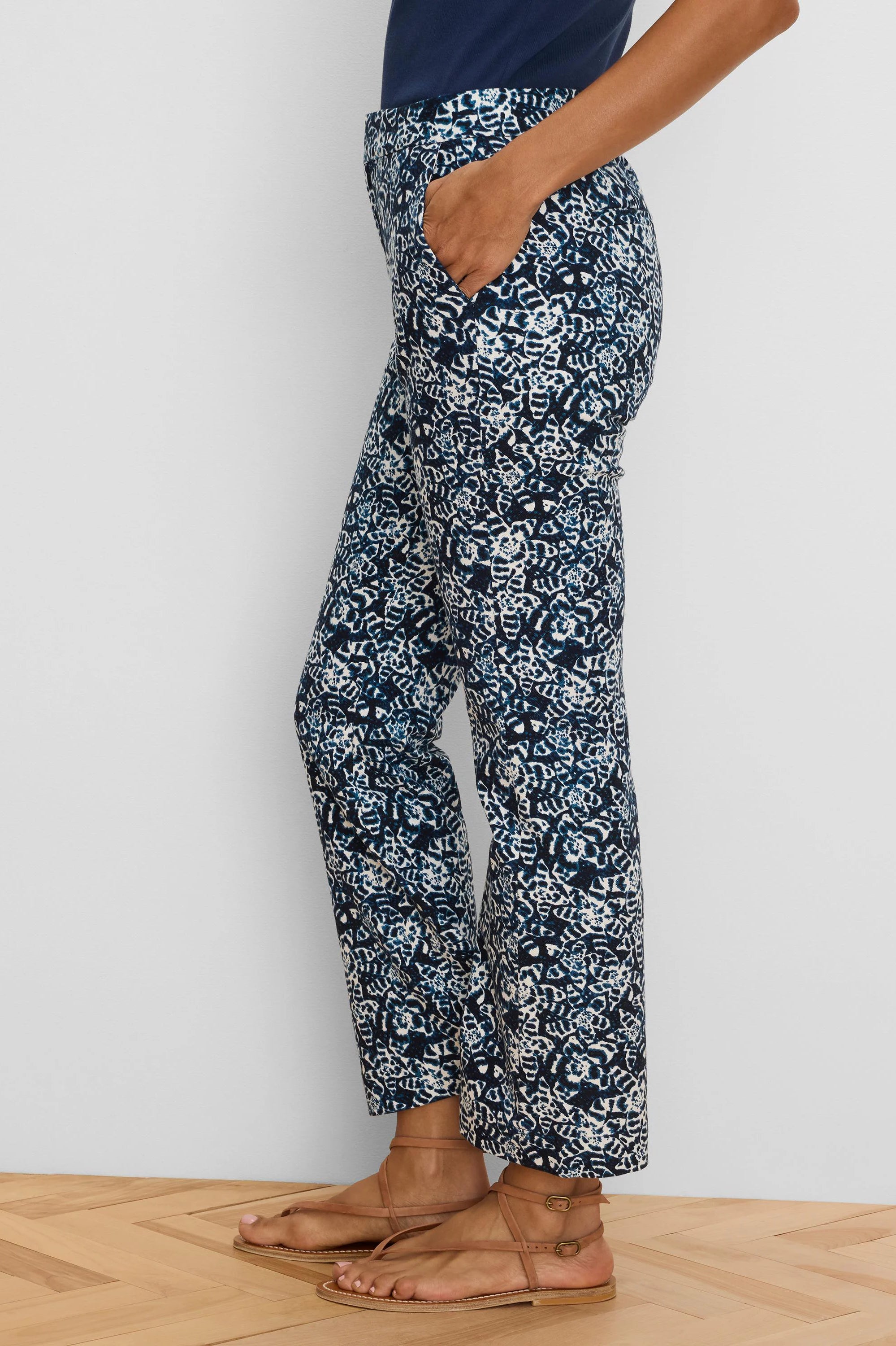 Dark blue ankle pants with white shibori lily pattern. Straight cut, ankle length. Model's hand in pocket.