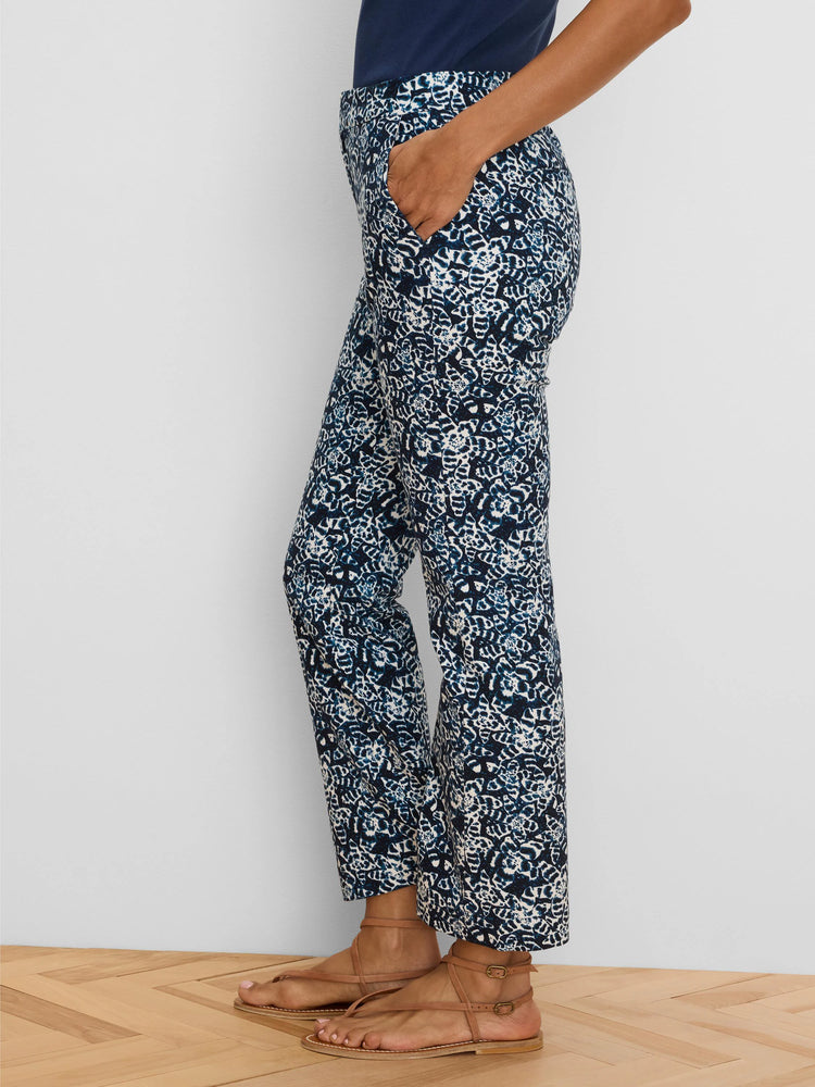 Dark blue ankle pants with white shibori lily pattern. Straight cut, ankle length. Model's hand in pocket.