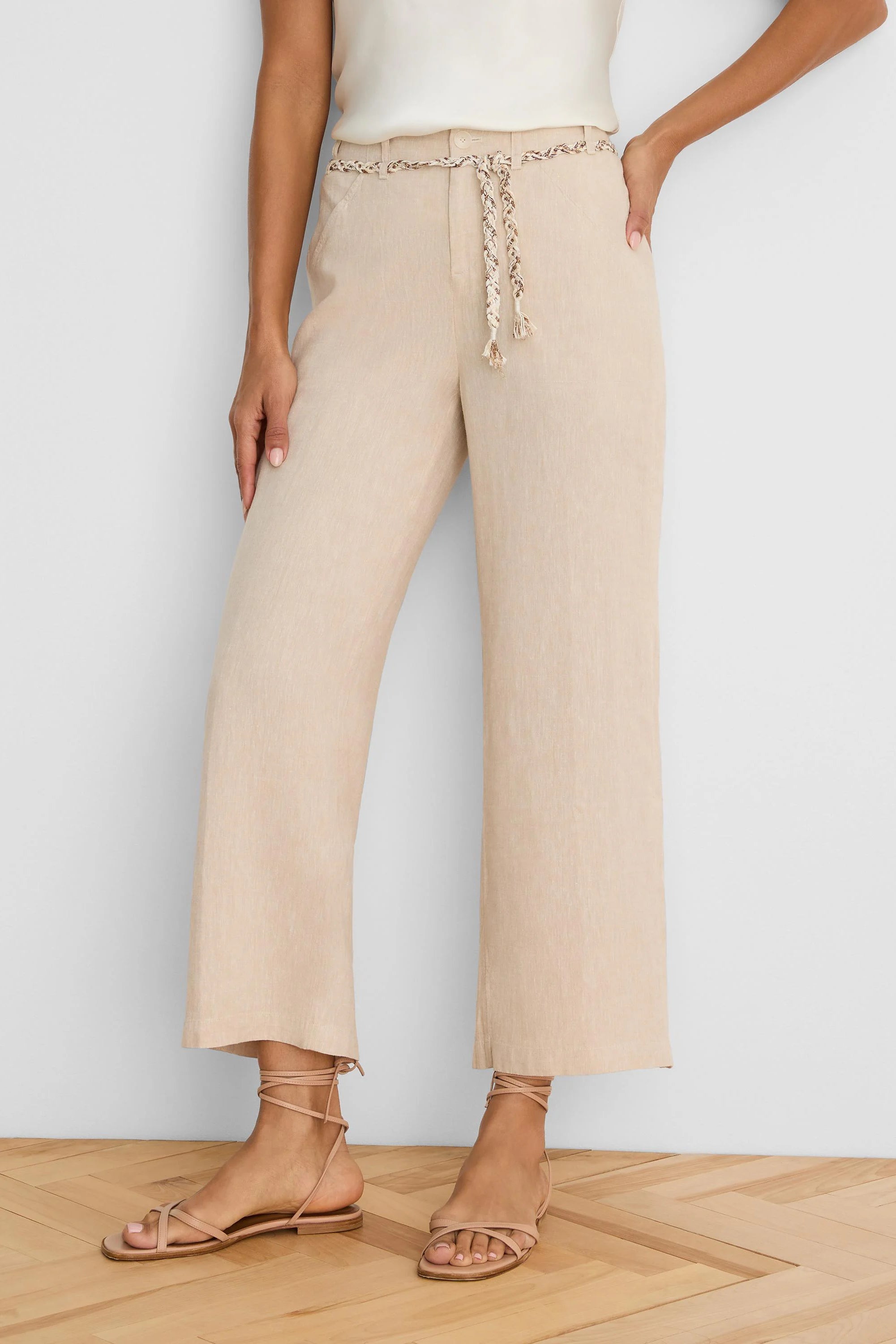 Light beige wide-leg linen crop pants feature a braided beige and brown patterned belt at the waist.