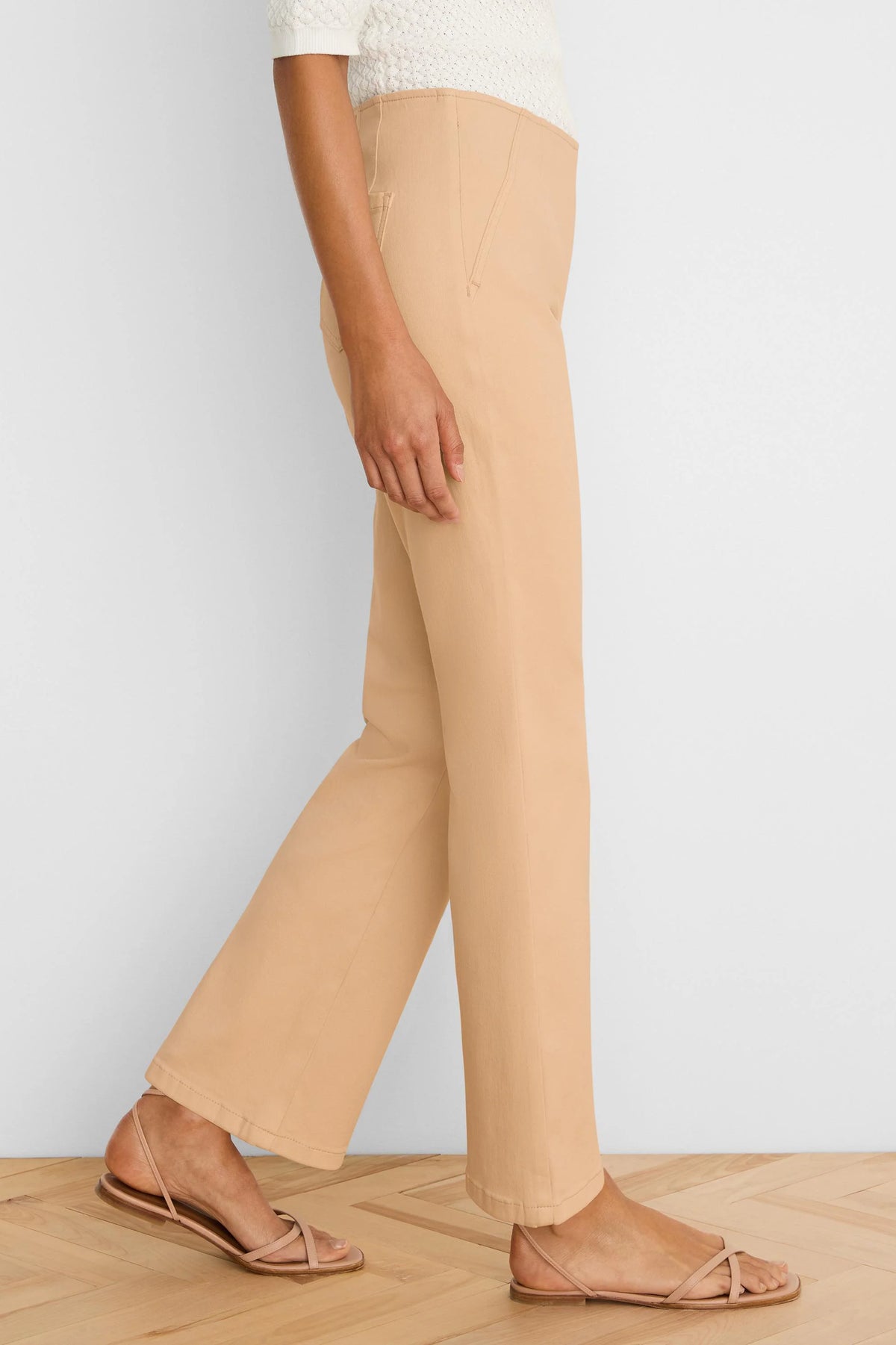 Light tan boot-cut jeans, high-waisted with a subtle flare, shown on a model from the side.