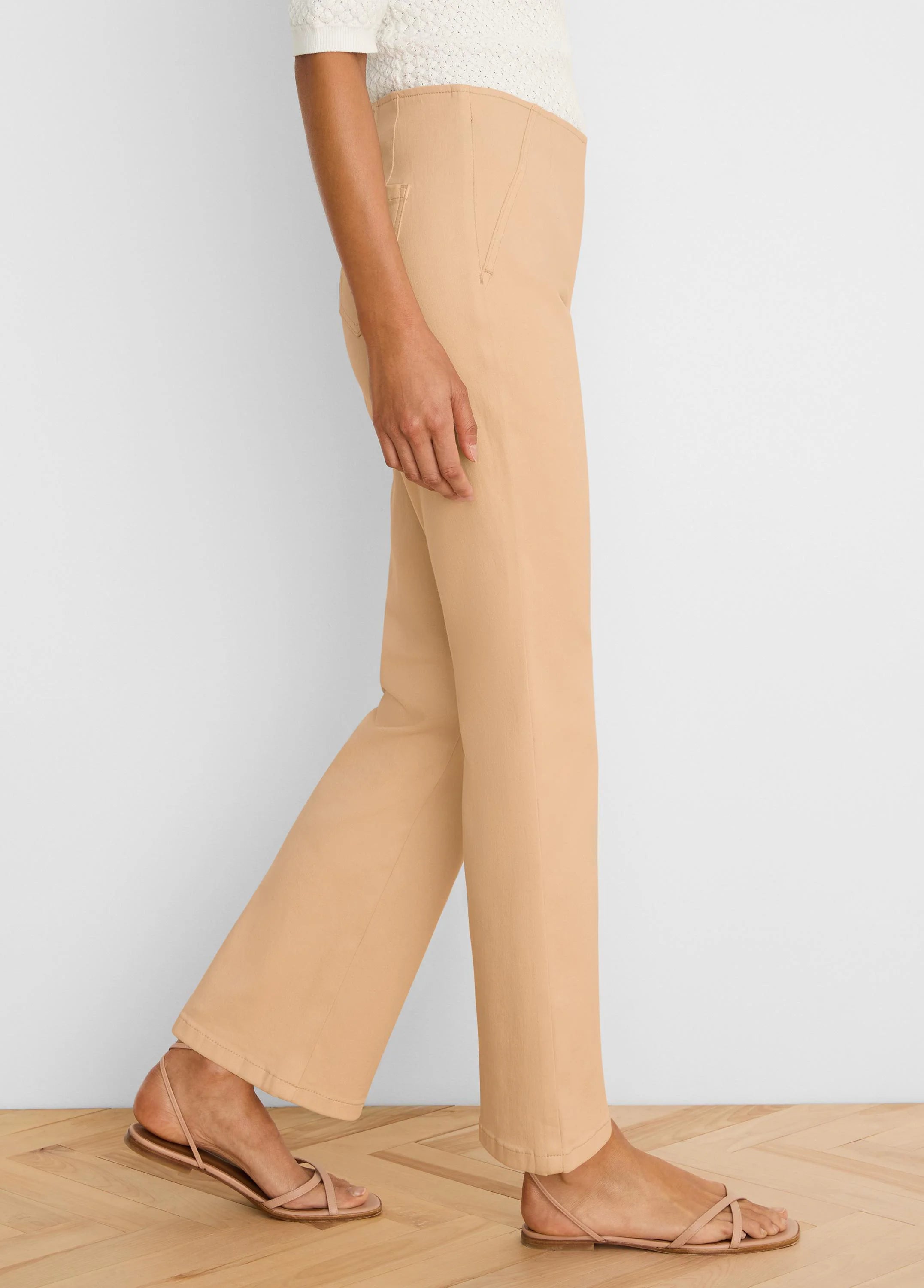 Light tan boot-cut jeans, high-waisted with a subtle flare, shown on a model from the side.