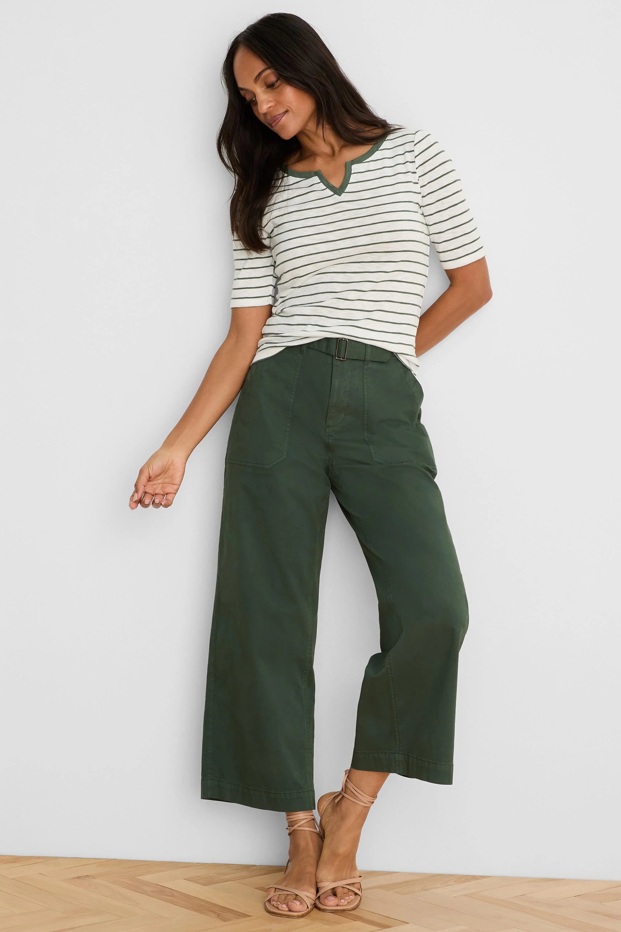 Dark green wide-leg ankle pants with a prominent belt, buckle, and visible vertical seams.