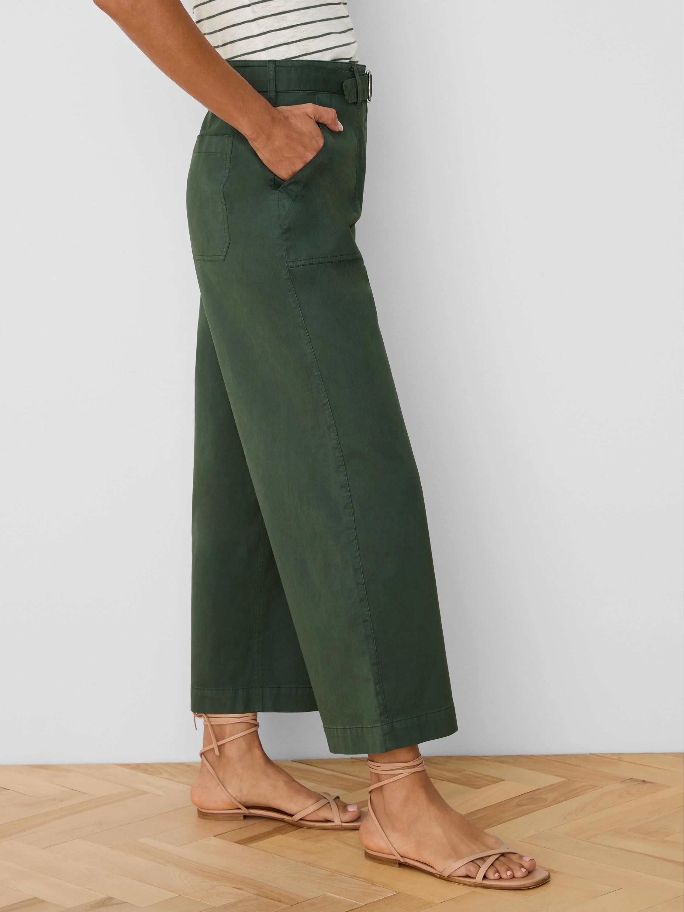 Dark green wide-leg ankle pants with a belted waist and side pockets.