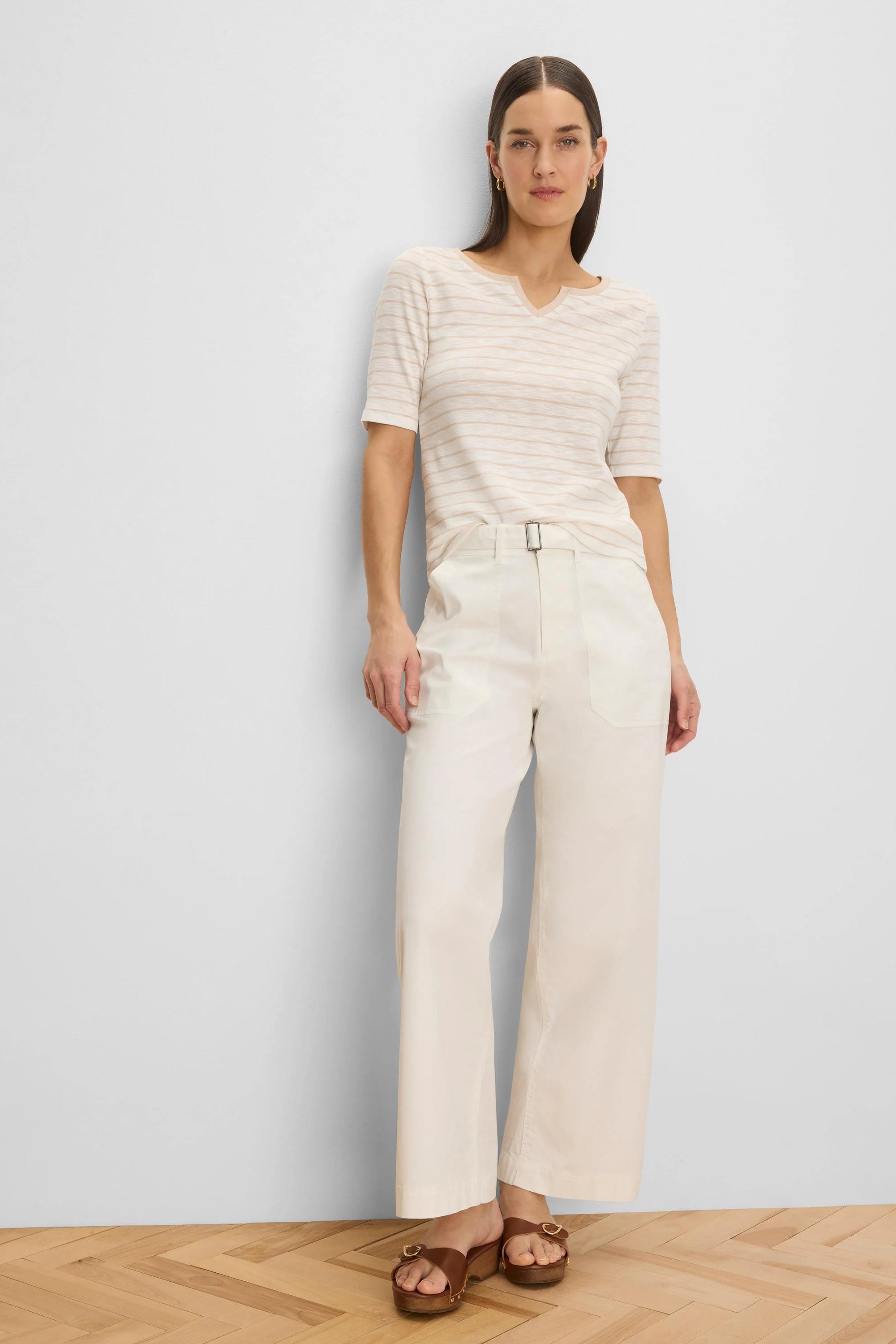 Cream wide-leg belted ankle pants with a rectangular buckle and side pockets.