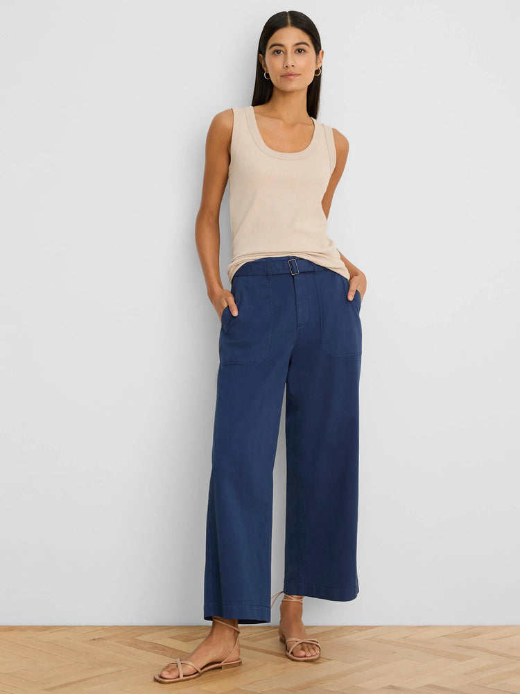 Dark blue wide-leg ankle pants with a belted waist, square silver buckle, and side pockets, worn by a model.