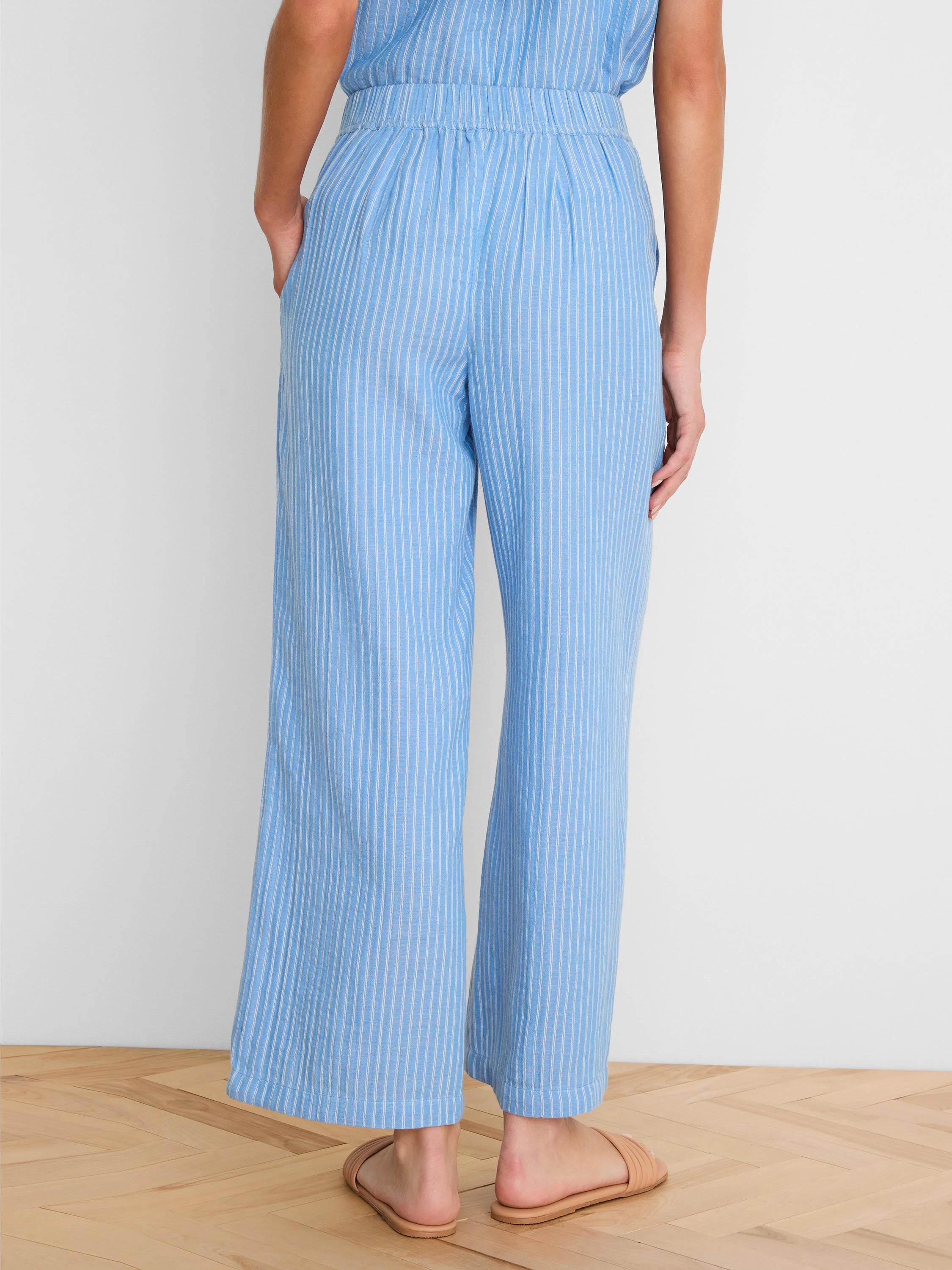 Light blue wide-leg gauze ankle pants with white vertical stripes, elastic waist, and side pockets.