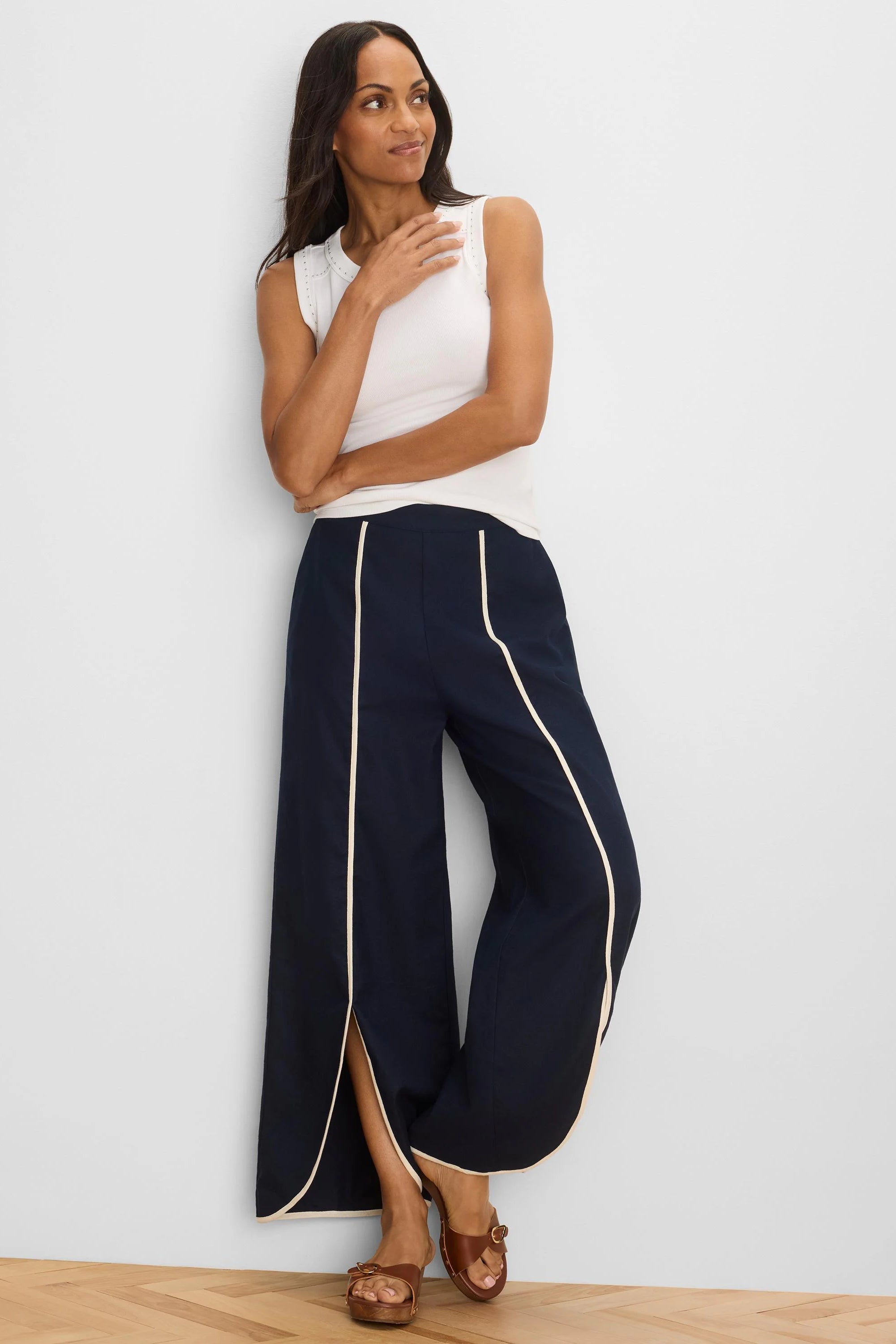 Navy wide-leg pants with cream piping outlining the split side seams.