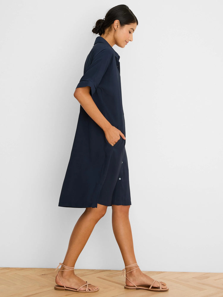 Navy dress with a collar, rolled short sleeves, side pockets, and white buttons on a side split. Above knee length.