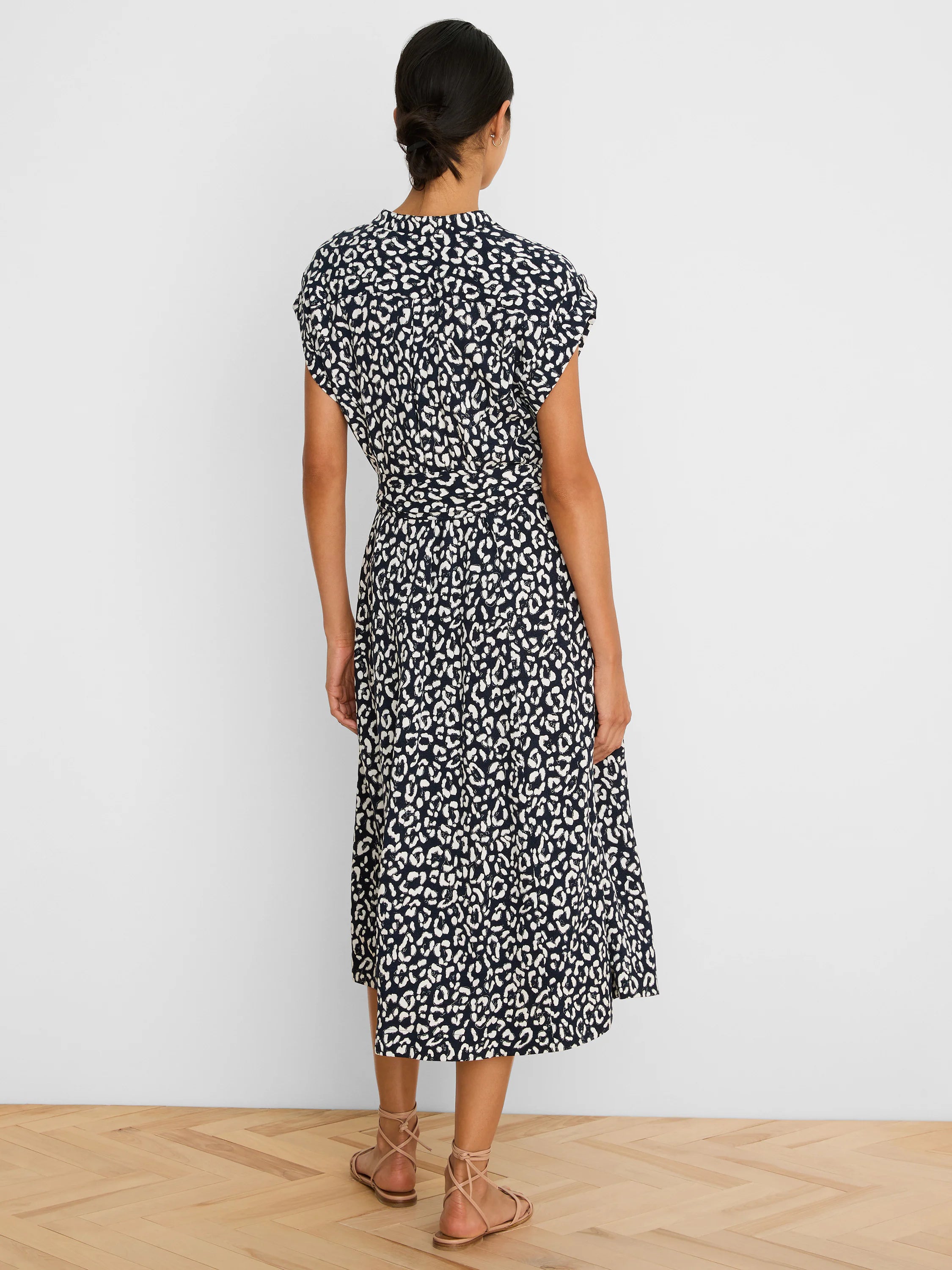 Navy and white leopard sketch midi dress with short sleeves and a tied waist, worn by a model from behind.