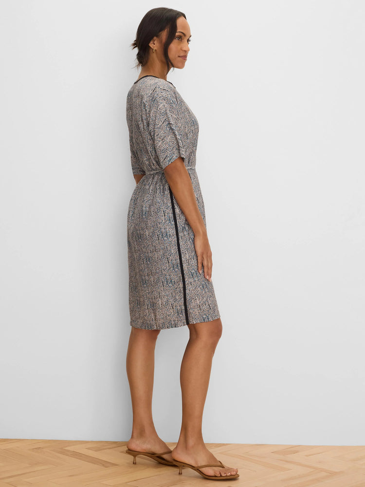 Knee-length dress with beige, blue & black speckle print. Features black trim at neckline and a vertical black side stripe.