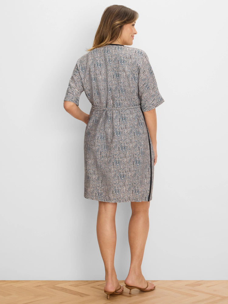 Light speckled dress with blue & black dots. Features black trim at neckline & side, short sleeves, and cinched waist.