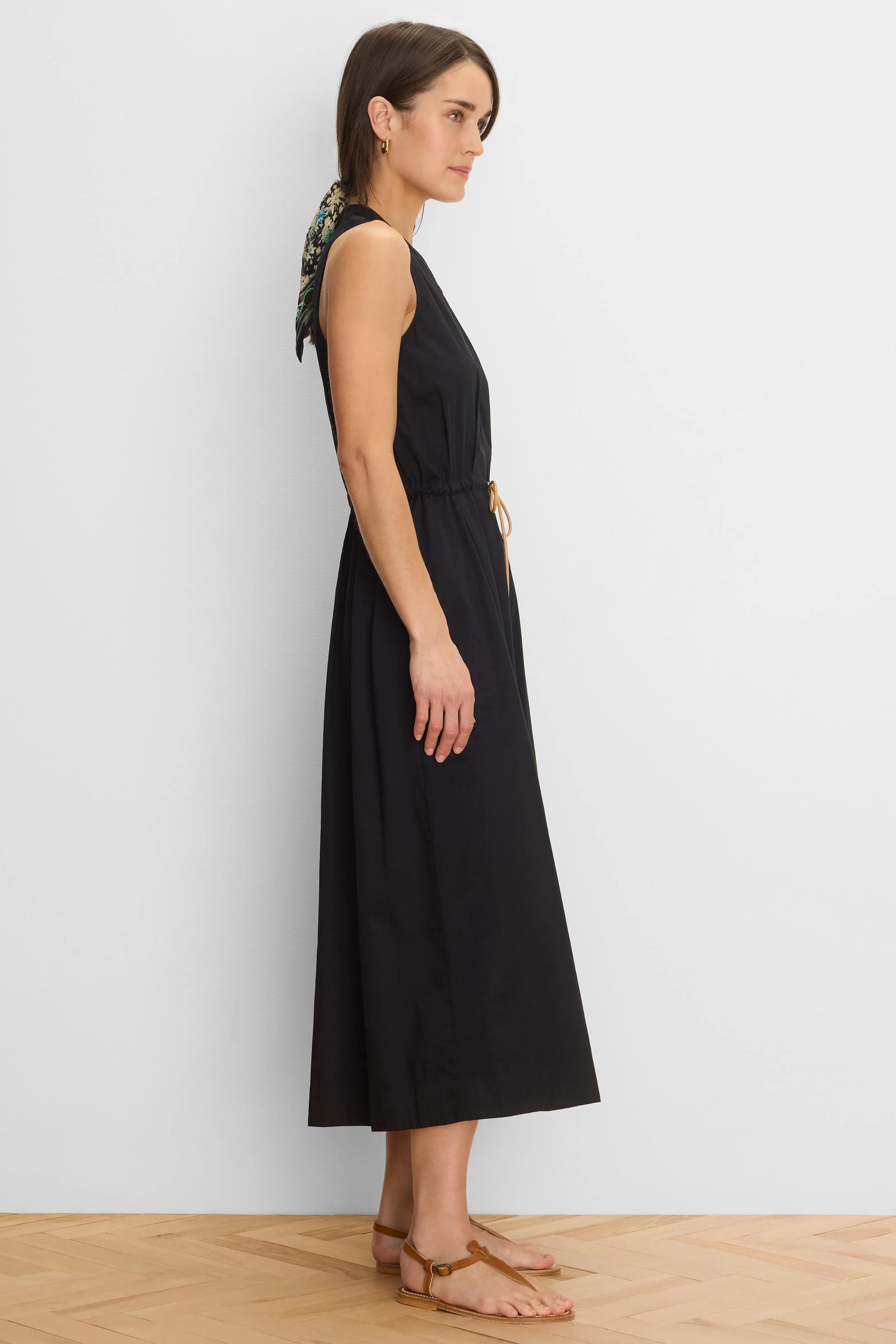Black sleeveless Sienna Dress with a gathered V-neck, tan drawstring waist, and midi length.