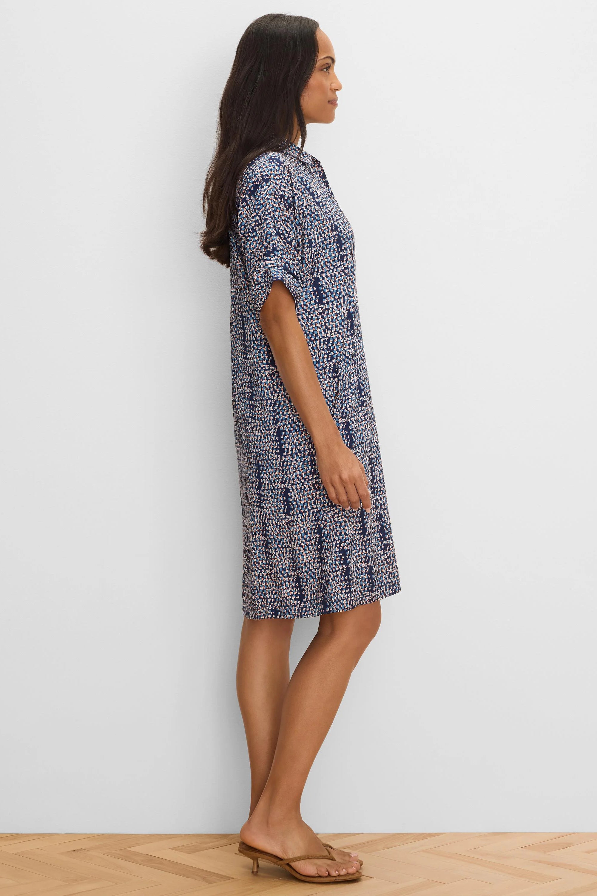 Navy knee-length dress with an abstract pattern of blue, white, & pink dots. Features a collar & short cuffed sleeves.