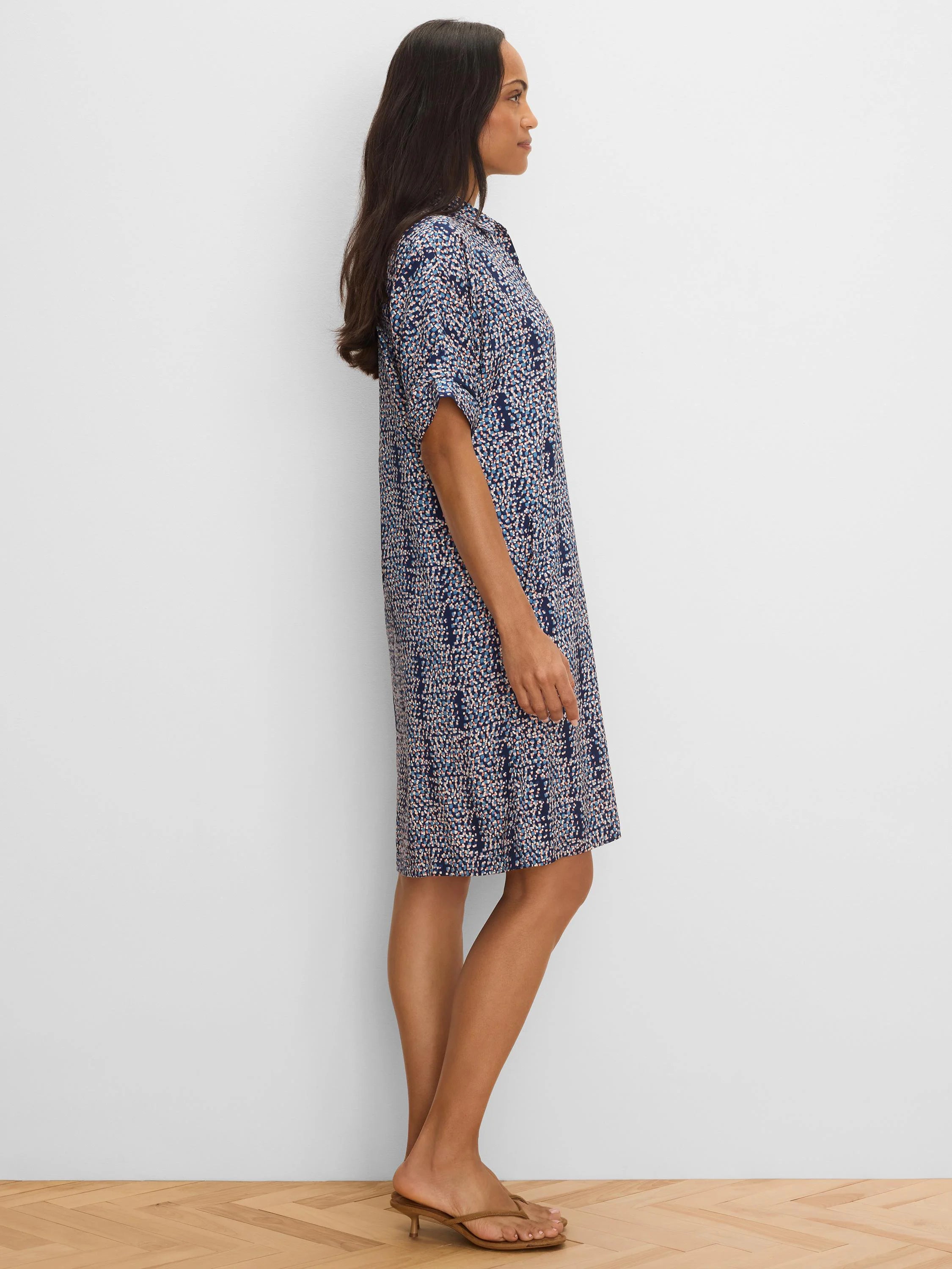 Navy knee-length dress with an abstract pattern of blue, white, & pink dots. Features a collar & short cuffed sleeves.