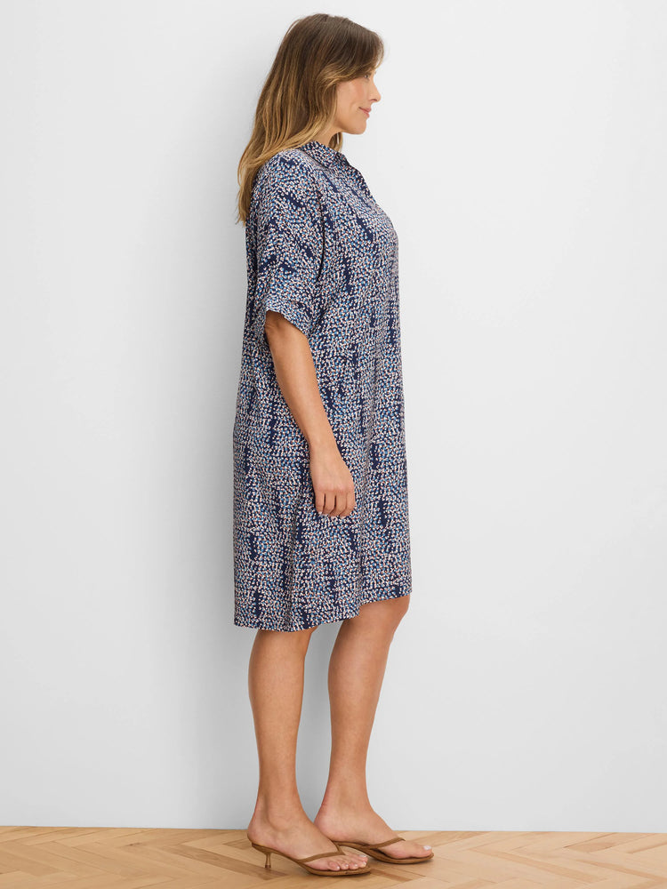 Navy collared dress with abstract light blue, white, and peach block pattern. Relaxed fit, elbow sleeves, above knee.