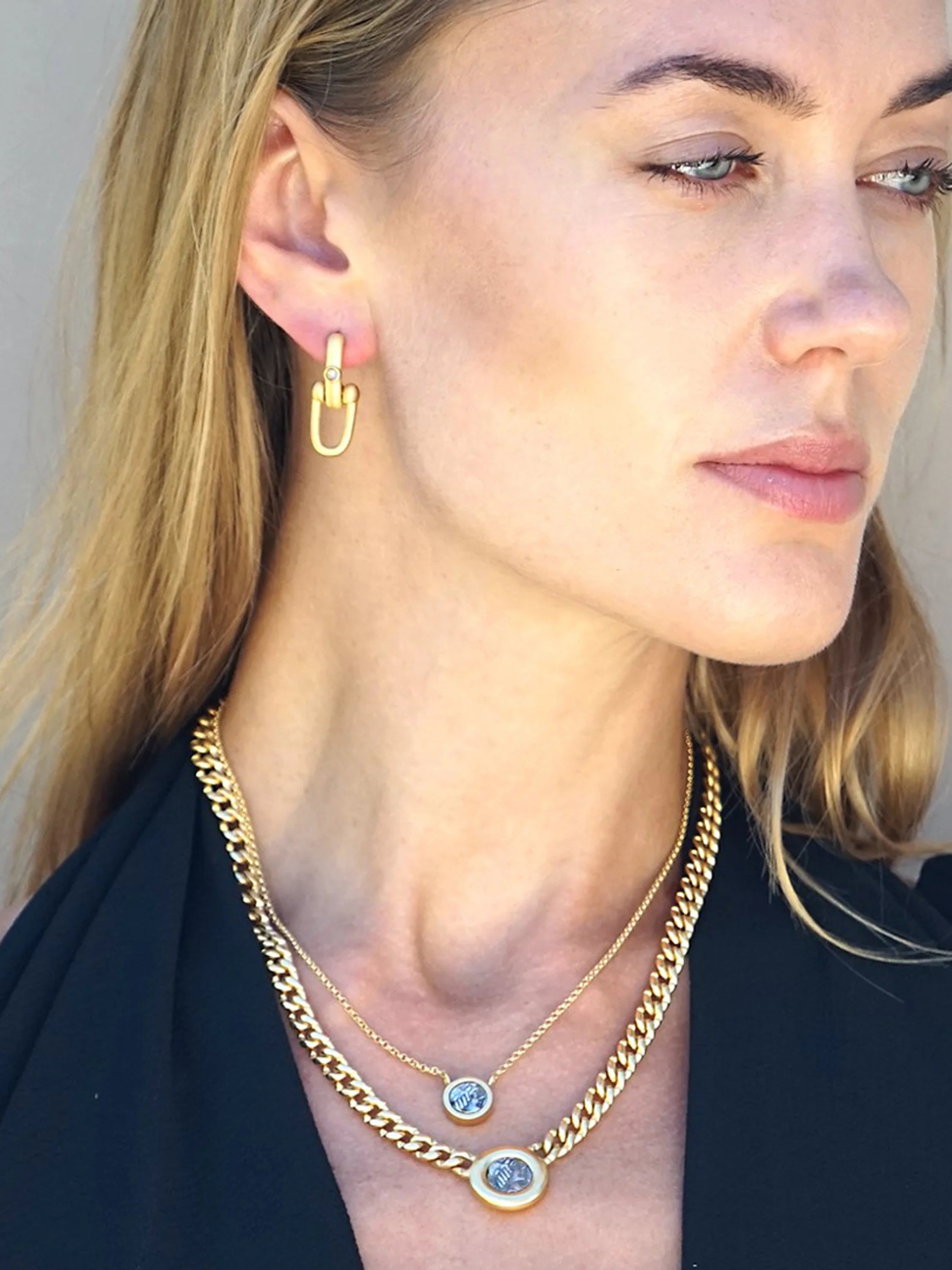 Gold necklace with two coin pendants; larger coin is framed in gold. A thinner gold chain is layered under a thicker...