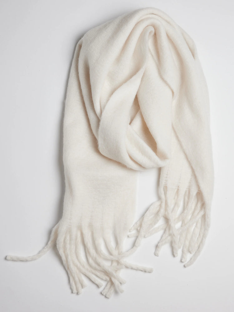 Off-white rectangular scarf with fringe. Soft, fuzzy texture.