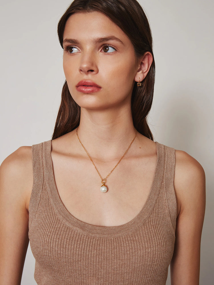Gold paperclip chain necklace with a white pearl pendant set in a gold cap.
