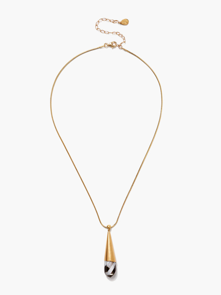 Gold chain necklace with teardrop pendant. Pendant is black, white, and gold; cone-shaped gold top.