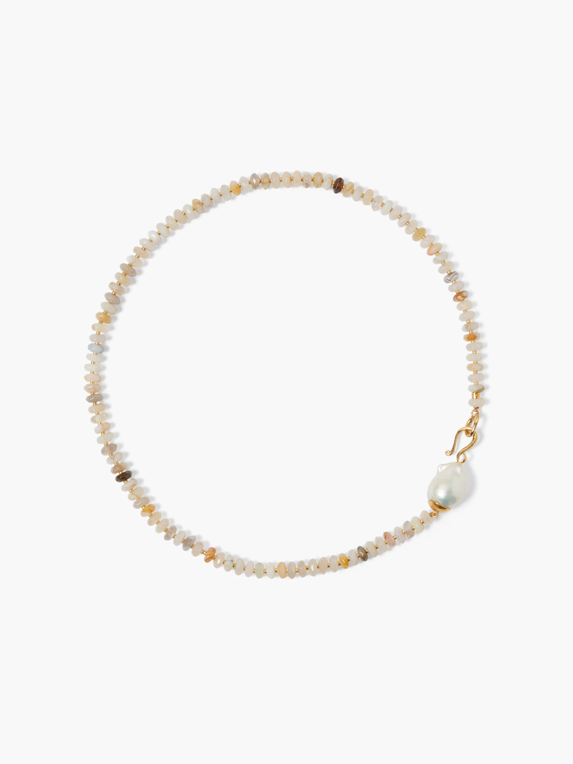 Small, flat, multicolor African opal beads form a necklace. It has a large white baroque pearl and gold hook clasp.